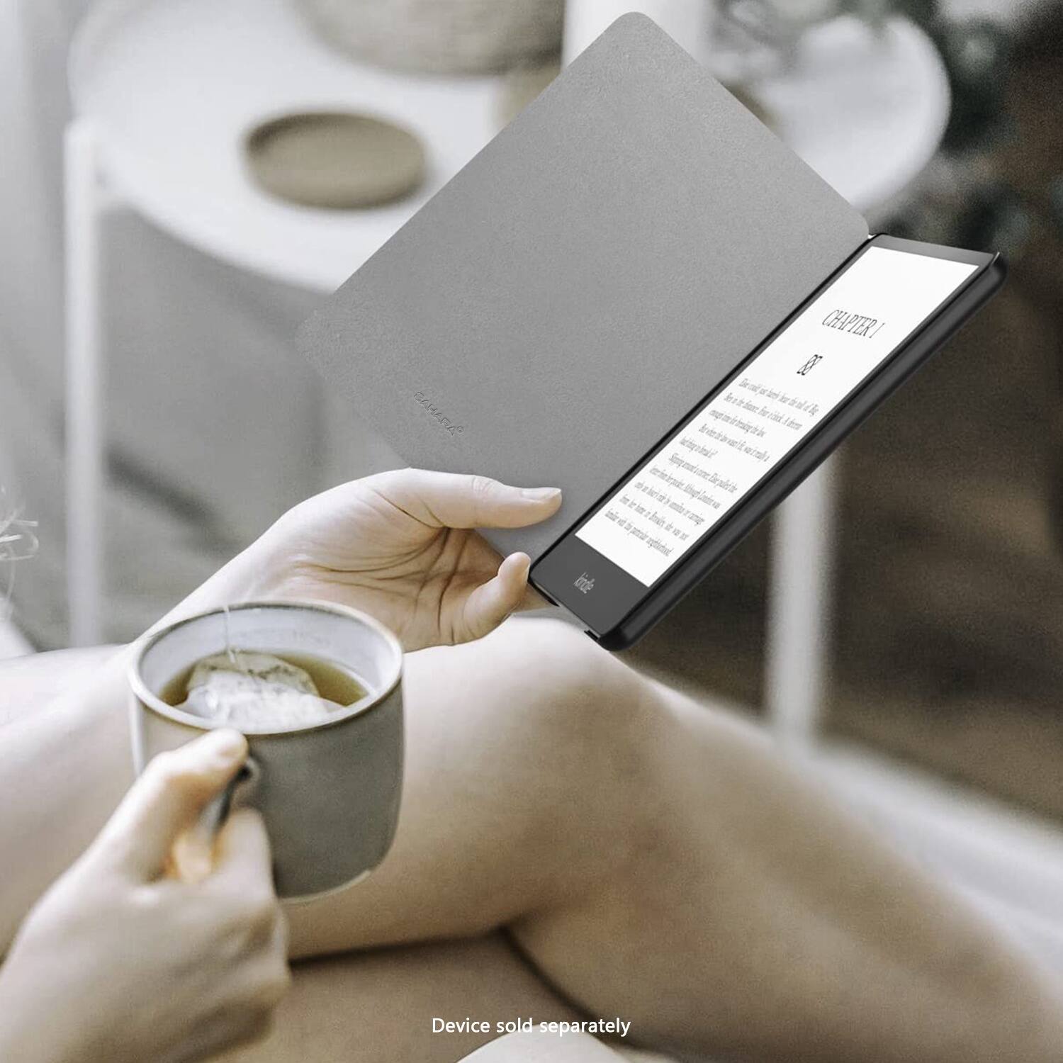 The image shows a woman sitting comfortably with a cup of tea and a tablet computer. She is holding the tablet in her hand, possibly reading or browsing the internet. The tablet is open to a page, and the woman is focused on the content displayed on the screen. The scene suggests a relaxing and leisurely activity, with the woman enjoying her time while engaging with the digital device.