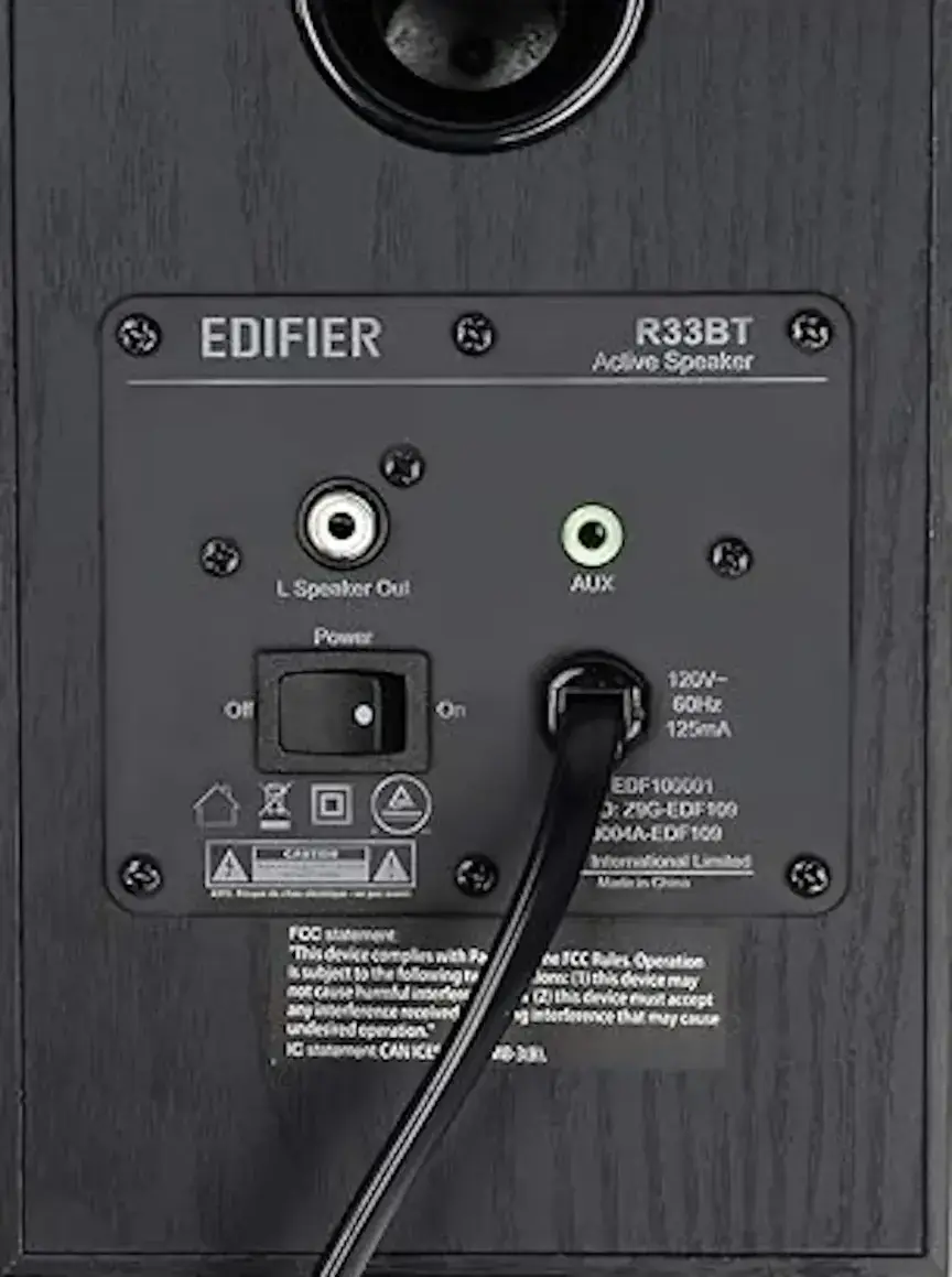 The text on the image reads: "EDIFIER R33BT Active Speaker L Speaker Out AUX Power On 120V-125mA EDF100001 C Z9G-EDF100 JOG4A-E DF 100 FOO." This text is not in any specific category or rule, but it is a description of an Edifier R33BT speaker.
