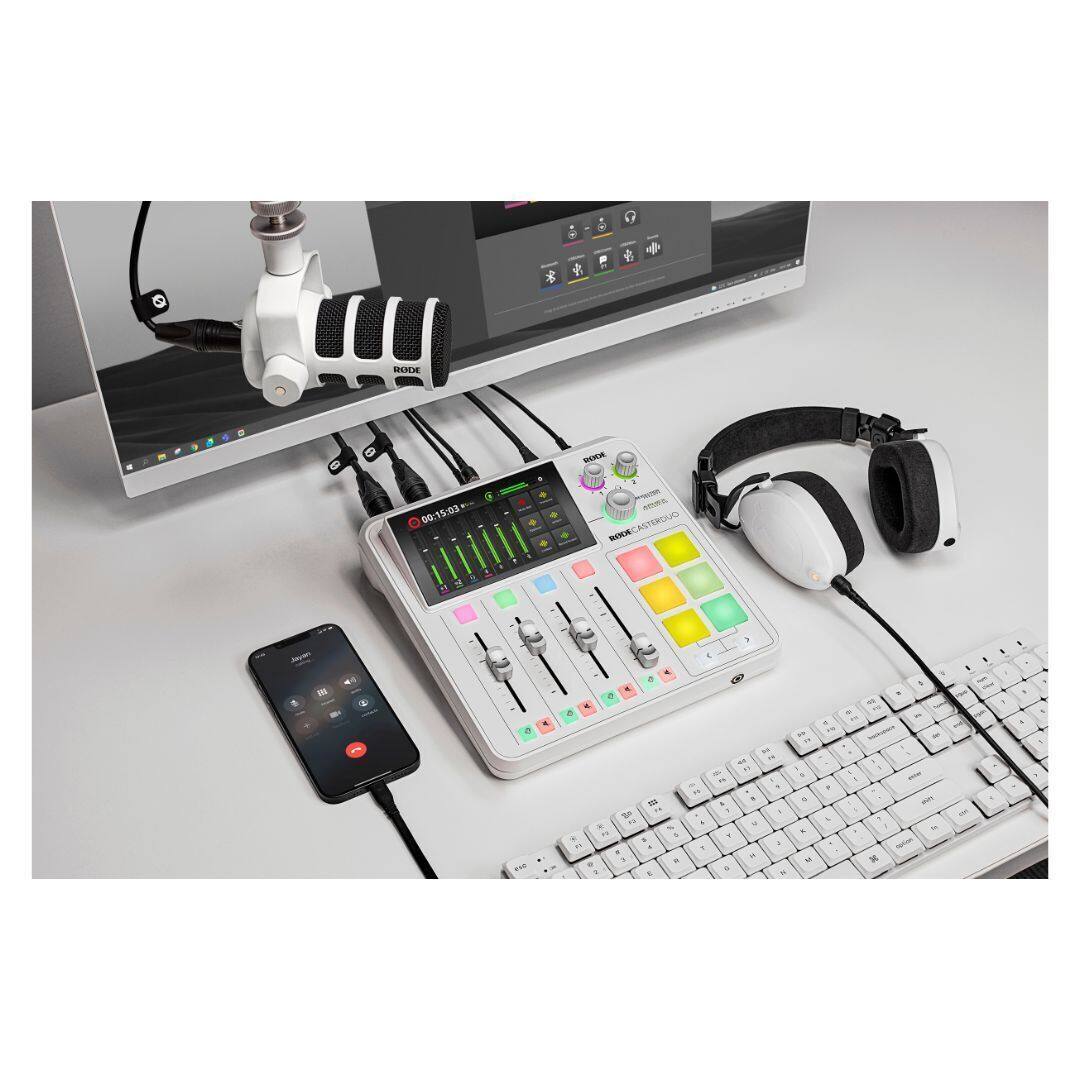 The image shows a desk with a computer, keyboard, and headphones. There is also a cell phone and a small device with a screen on the desk. The headphones are placed next to the keyboard, and the cell phone is located near the keyboard as well. The desk setup appears to be for work or entertainment purposes, with the computer and keyboard providing a means to access digital content, while the headphones and cell phone offer additional communication and entertainment options.