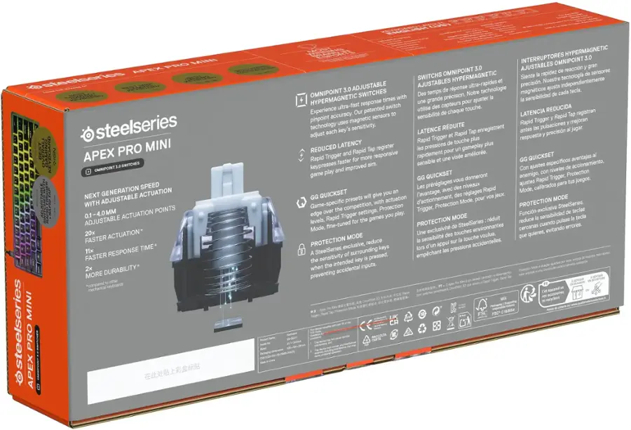 The image features a box for the Steelseries Pro Mini Apex gaming headset. The box is orange and gray, and it contains a headset with a microphone and a manual. The headset is designed for gaming and provides an immersive audio experience. The box also includes a warranty card for added peace of mind.
