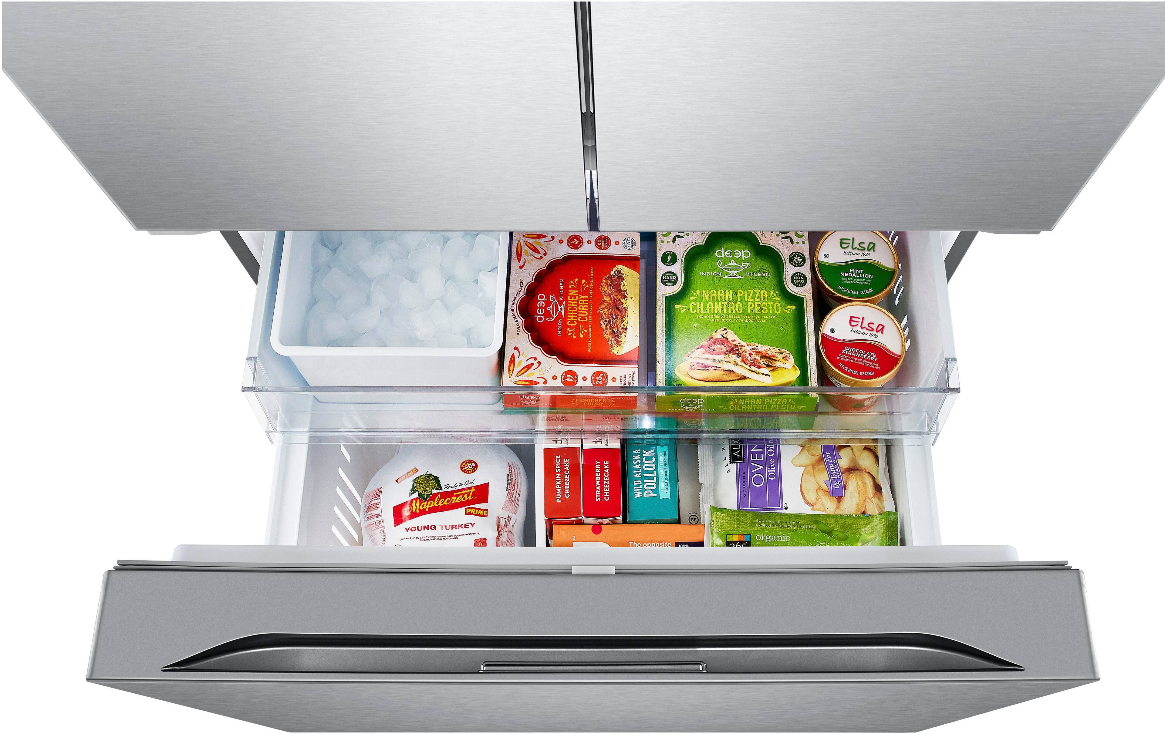 The image shows the inside of a refrigerator with several food items stored in it. There are multiple bottles placed in various compartments, including a bottle of chicken curry, a bottle of pizza sauce, and a bottle of maple syrup. Additionally, there are two bowls, one containing ice and the other containing a frozen pizza. The refrigerator also has a compartment for fresh produce, which is currently empty. The image provides a clear view of the various food items stored in the refrigerator, showcasing its organization and storage capabilities.