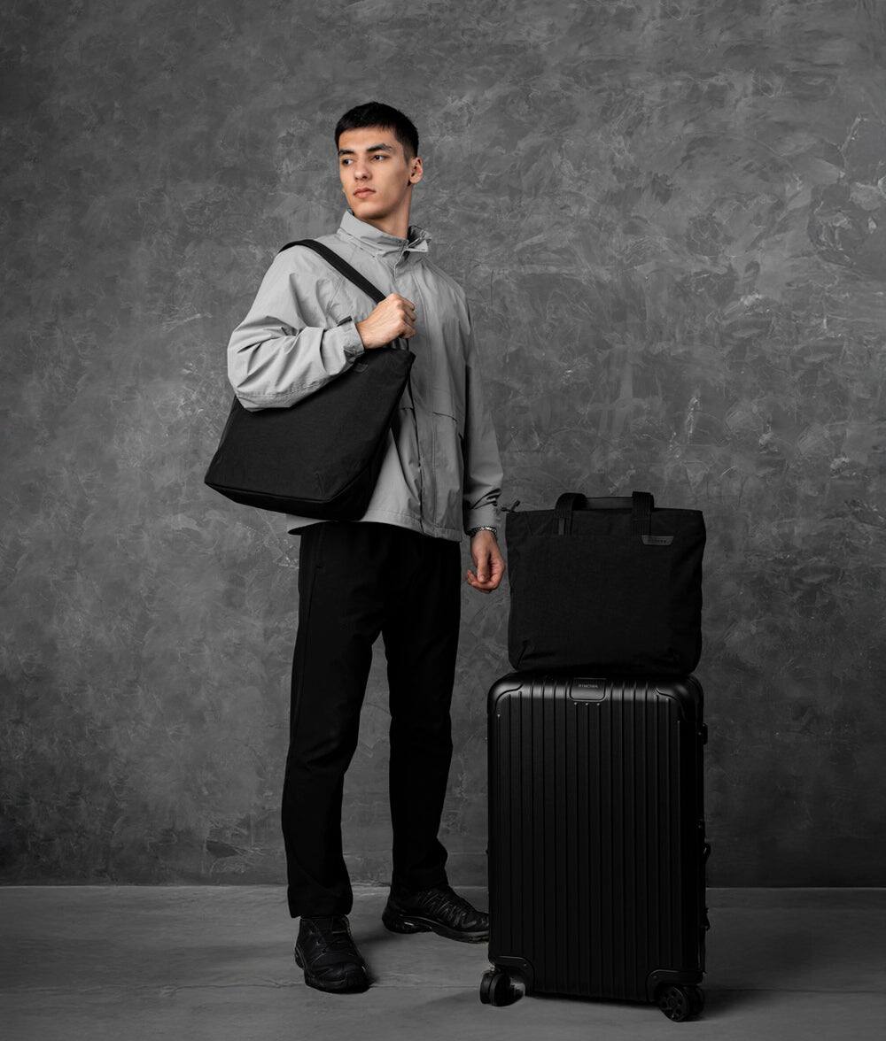 Angle. ALPAKA - Flight Tote (L) Laptop Tote Bag for Work, Large Tote Bag Fits 16" MacBook Pro, Water Bottle Pocket, Luggage Pass-Through - Black Axoflux 400D.