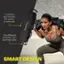 The image features a woman wearing a gray shirt and holding a black bag. The bag has a smart design, which includes seven comfort grip handles for variety in exercises. The bag is designed to fit different shoulder, arm, and hand sizes, making it a versatile and practical piece of equipment for various workout routines.