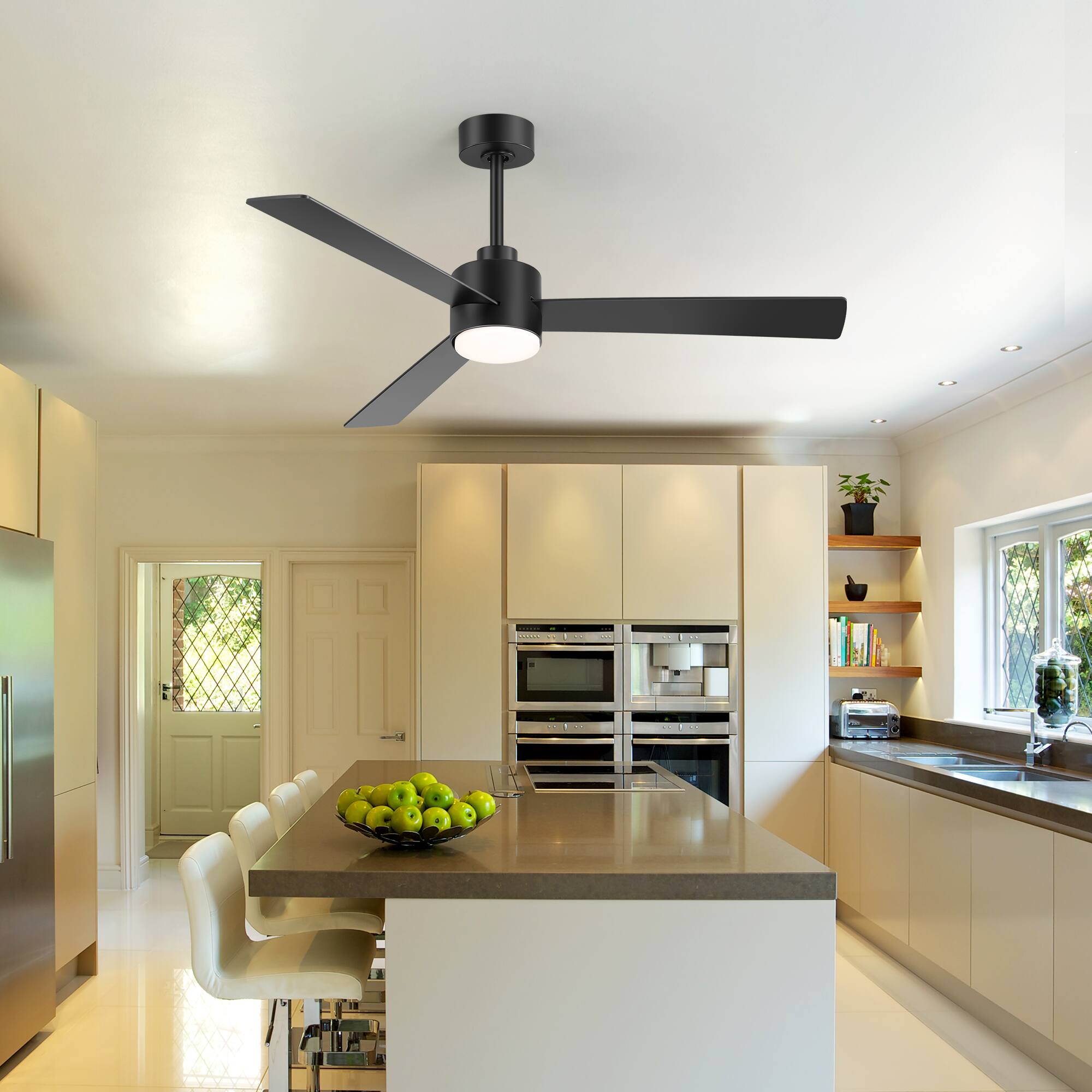 The text in the image is not clearly visible, so I cannot provide a correction or grouping based on the text. However, I can describe the image:

This is a modern kitchen with a central island featuring a bowl of green apples. The kitchen has light-colored cabinets, stainless steel appliances, and a large window with a view of greenery. There is a ceiling fan with a light fixture above the island, and the room is well-lit with natural light.