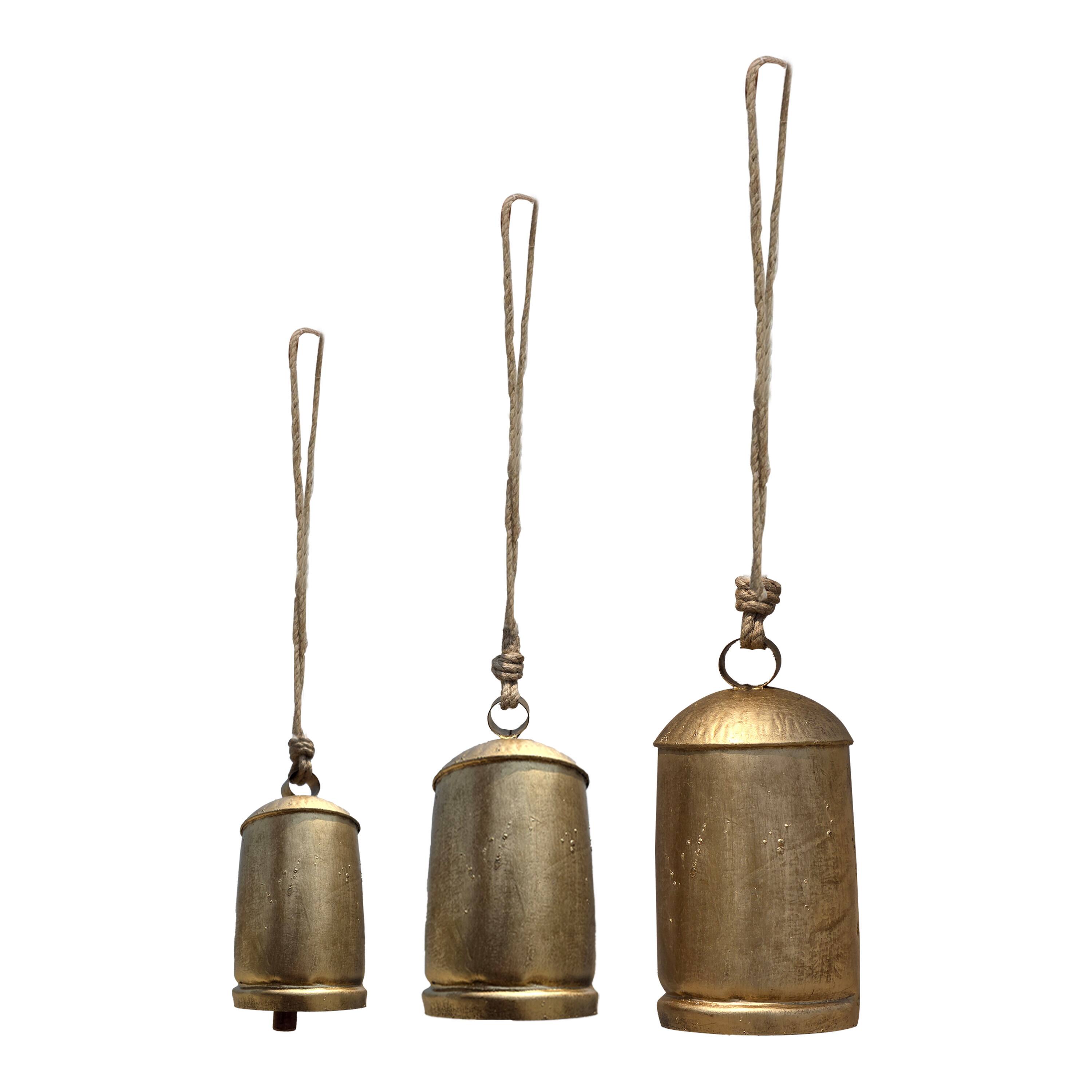 Front. Manhattan Lane - Zaira Decorative Iron Cow Bells Set of 3 | Cylindrical | Antique Gold Finish| Jute Hanging Rope | 20, 15, 12 Inches - Gold.
