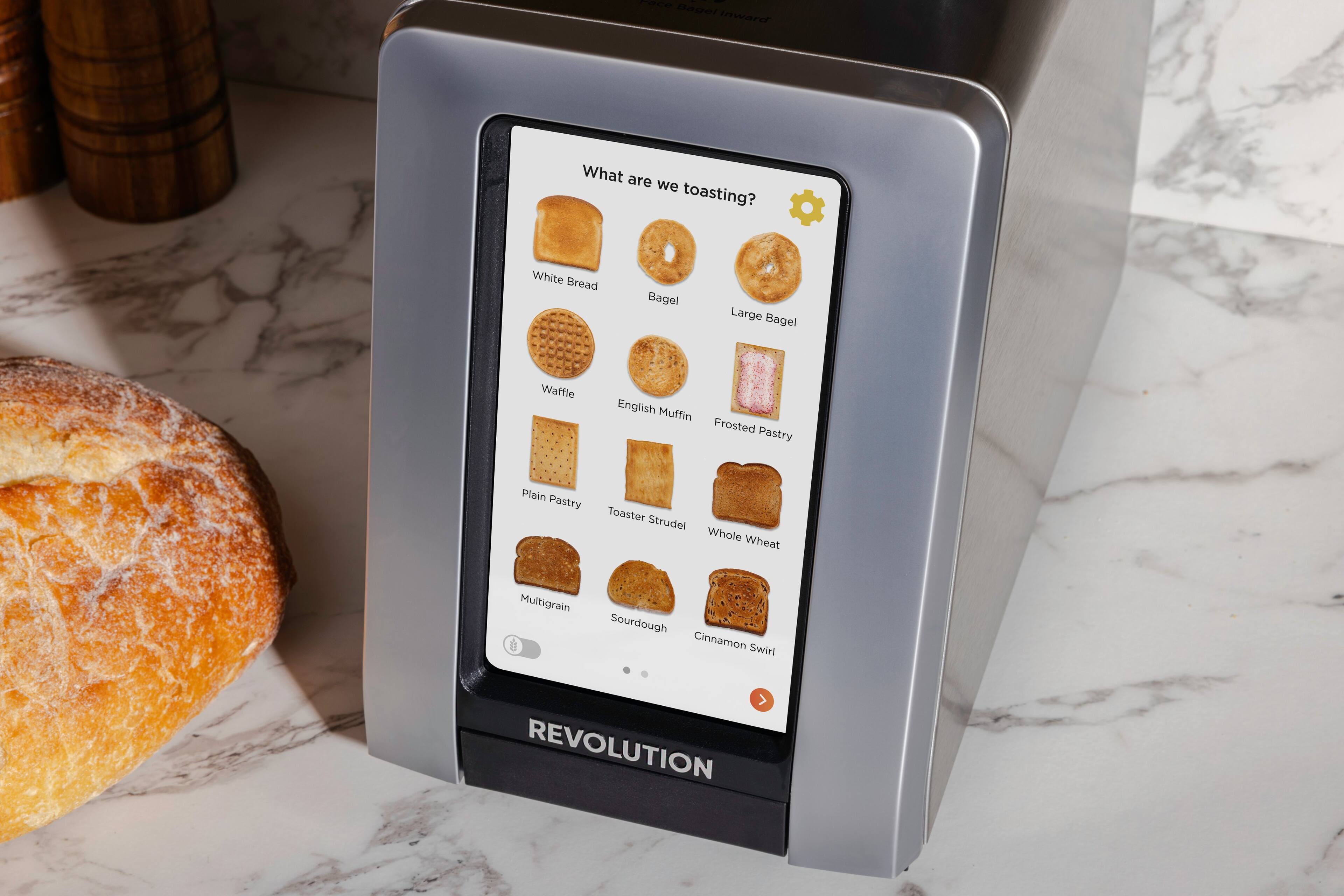 The image shows a toaster with a display screen showing various types of bread and pastries, including white bread, bagel, large bagel, waffle, English muffin, frosted pastry, plain pastry, and toaster strudel. The toaster is made by Revolution.