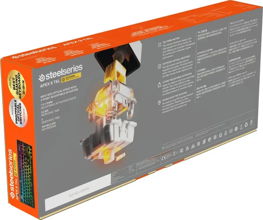 The image features a box for the Steelseries Apex 6 TKL gaming keyboard. The box is orange and white, and it contains information about the keyboard's features and specifications. The Apex 6 TKL is a compact tenkeyless design that offers a comfortable typing experience with a minimalist form factor. It is equipped with optical switches that provide instant response and a 2-point adjustable actuation for different key press sensitivity. The box also includes a set of PBT keycaps, which are designed for durability and aesthetics. The Apex 6 TKL is ideal for gamers and competitive players who require a high-performance keyboard with a compact design.