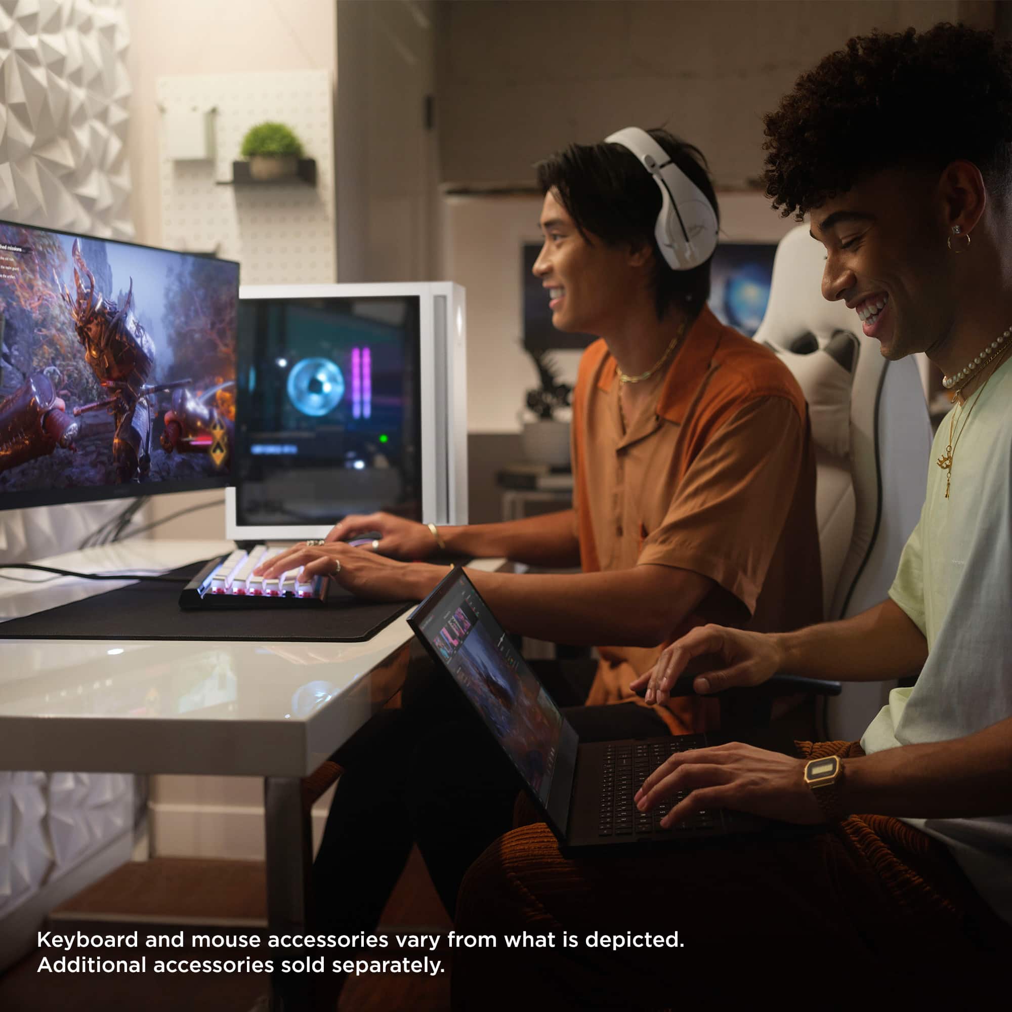 The image shows two men sitting at a table with laptops, keyboards, and mice. The text on the image states that the keyboard and mouse accessories may vary from what is depicted and that additional accessories are sold separately.