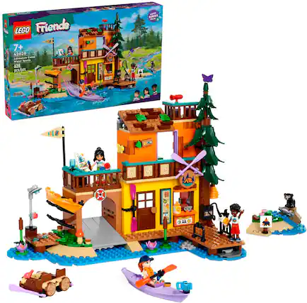 The image features a Lego Friends Adventure Camp playset, which includes a water sports area and a campground. The playset is designed for children aged 7 and up and has 628 pieces. The scene includes a group of people, some of whom are wearing backpacks, and a boat. There is also a dog present in the scene. The playset is designed to encourage imaginative play and creativity among children.