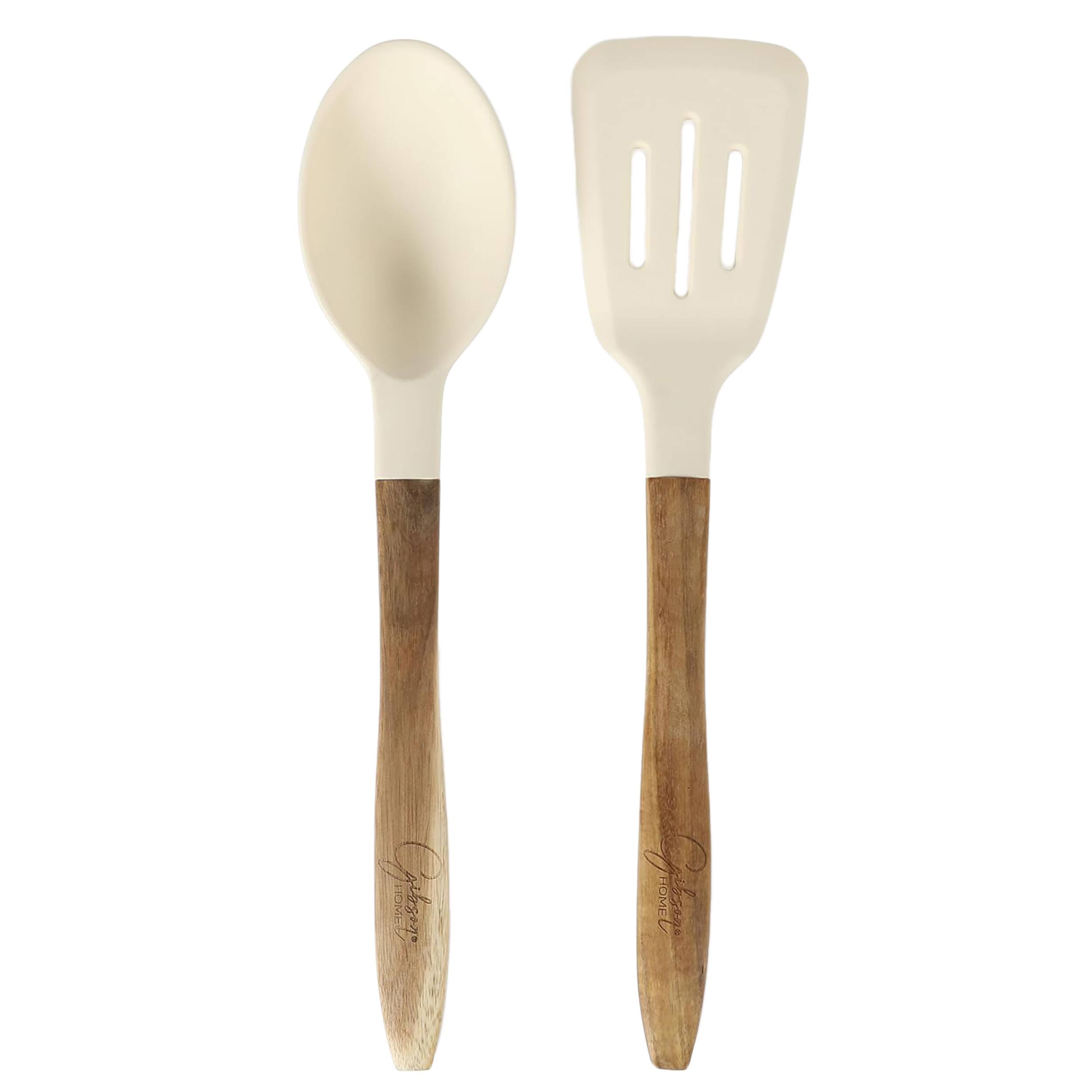 The image shows two wooden utensils, a spoon and a fork, sitting next to each other. The spoon is white and made of wood, while the fork is also white and made of wood. The utensils are placed in a white background, making them stand out prominently.