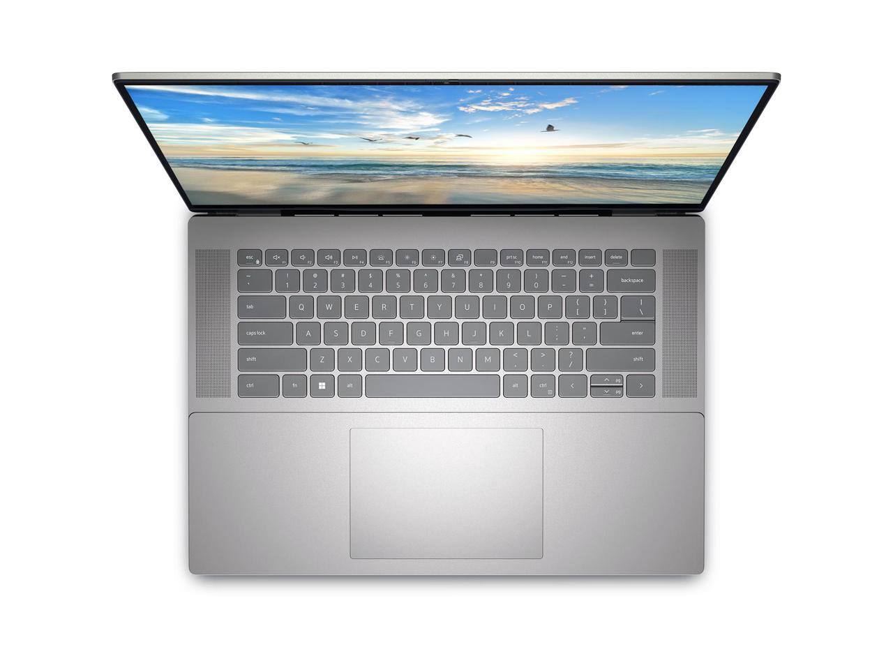 A laptop with a keyboard and a screen displaying a beach scene.