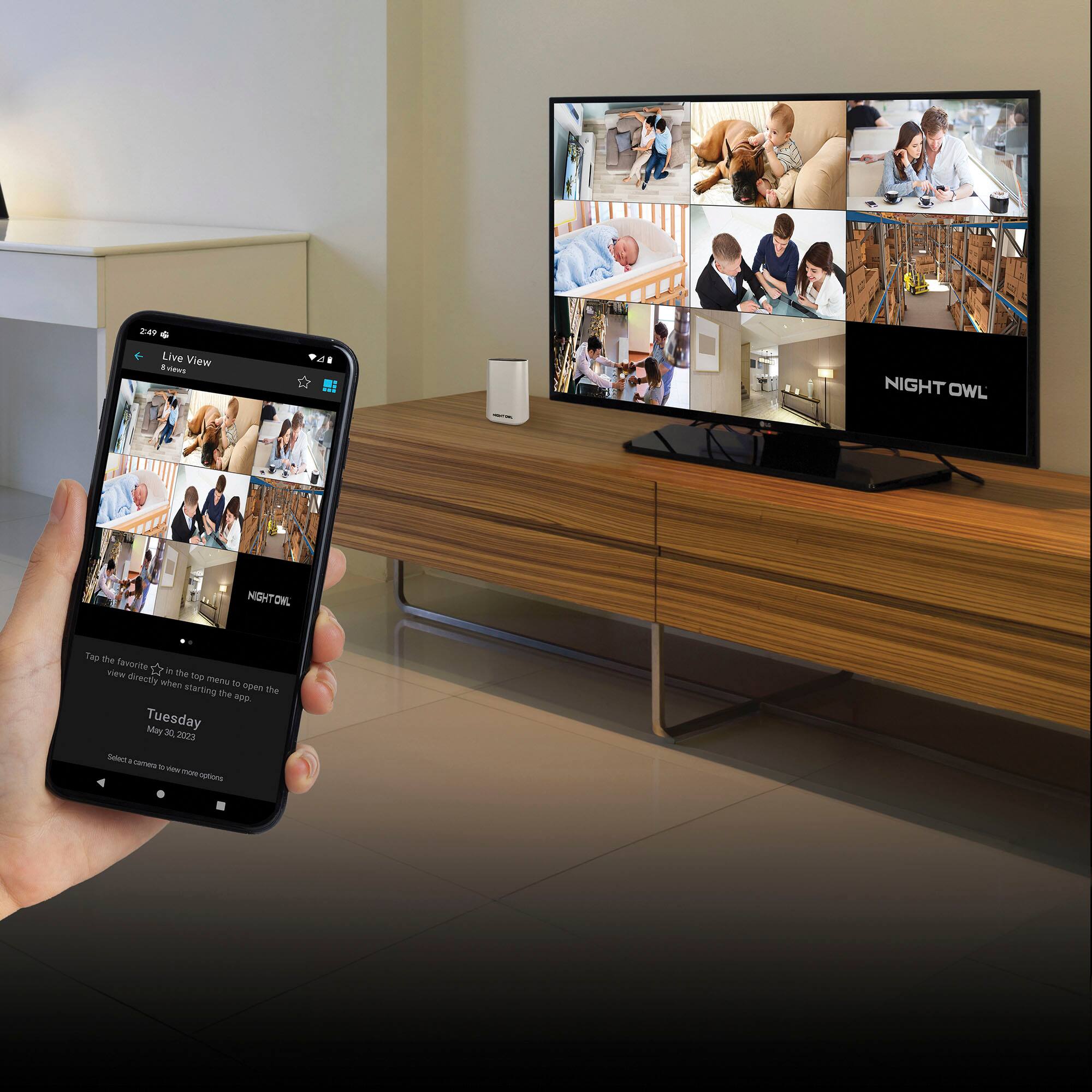 The image shows a person holding a cell phone with the text "Night Owl" on the screen. The phone is displaying a live view of a television, which is showing a program. The person is likely watching the program on the television through their cell phone. The image also shows a couch in the background, suggesting that the person is in a living room or a similar indoor setting.