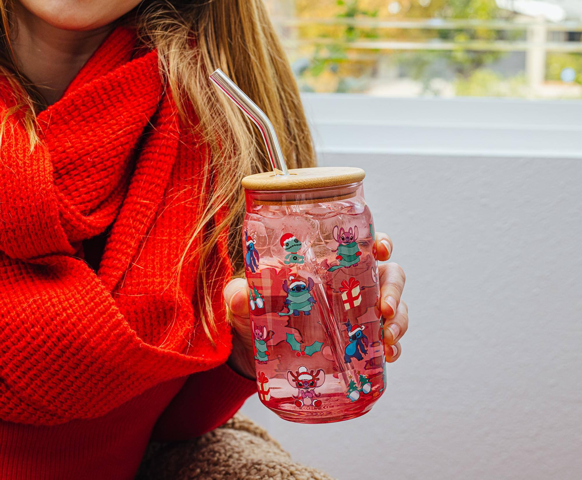 The text on the image is not clearly visible, so I cannot provide a correction. However, the image shows a person holding a glass jar with a festive design featuring cartoon characters in Christmas attire.