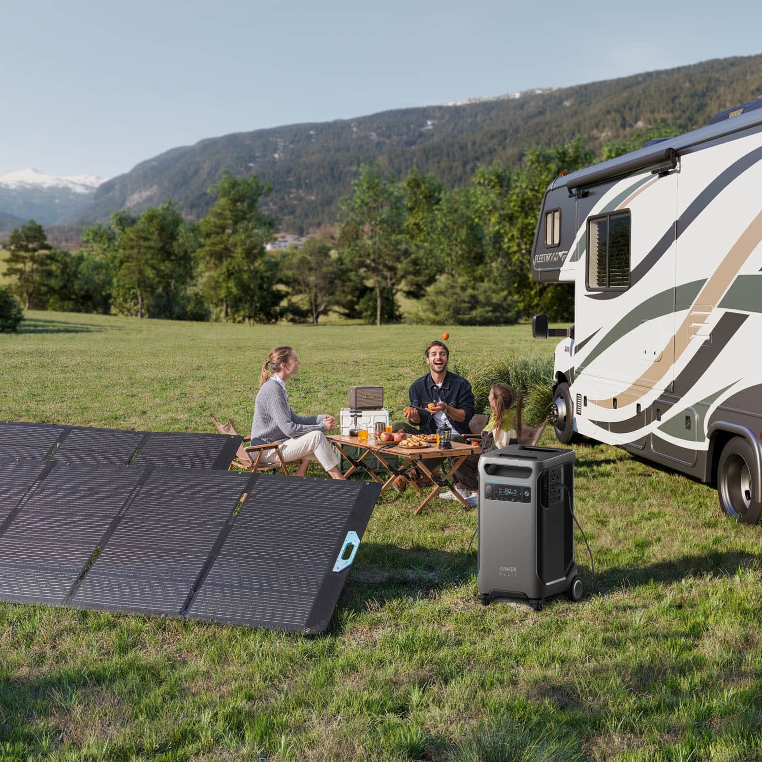 A group of people are sitting outside of a camper trailer, enjoying a meal together. They are surrounded by a solar panel, a portable grill, and a dining table. The family appears to be having a good time, with various items such as a bottle, a cup, and a bowl placed on the table. The scene captures a moment of togetherness and outdoor leisure.