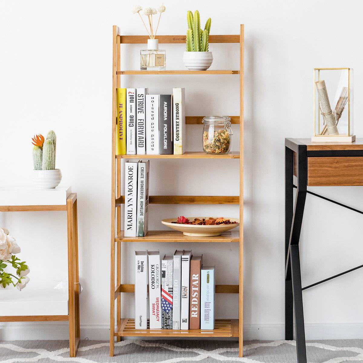The image features a wooden bookshelf with various books and items on it. There are several books of different sizes and colors arranged on the shelf, along with a bowl of fruit and a vase with flowers. The bookshelf is placed next to a table, creating a cozy and organized space for reading and enjoying the decorative elements. The presence of the books and the vase with flowers adds a touch of warmth and personality to the room.