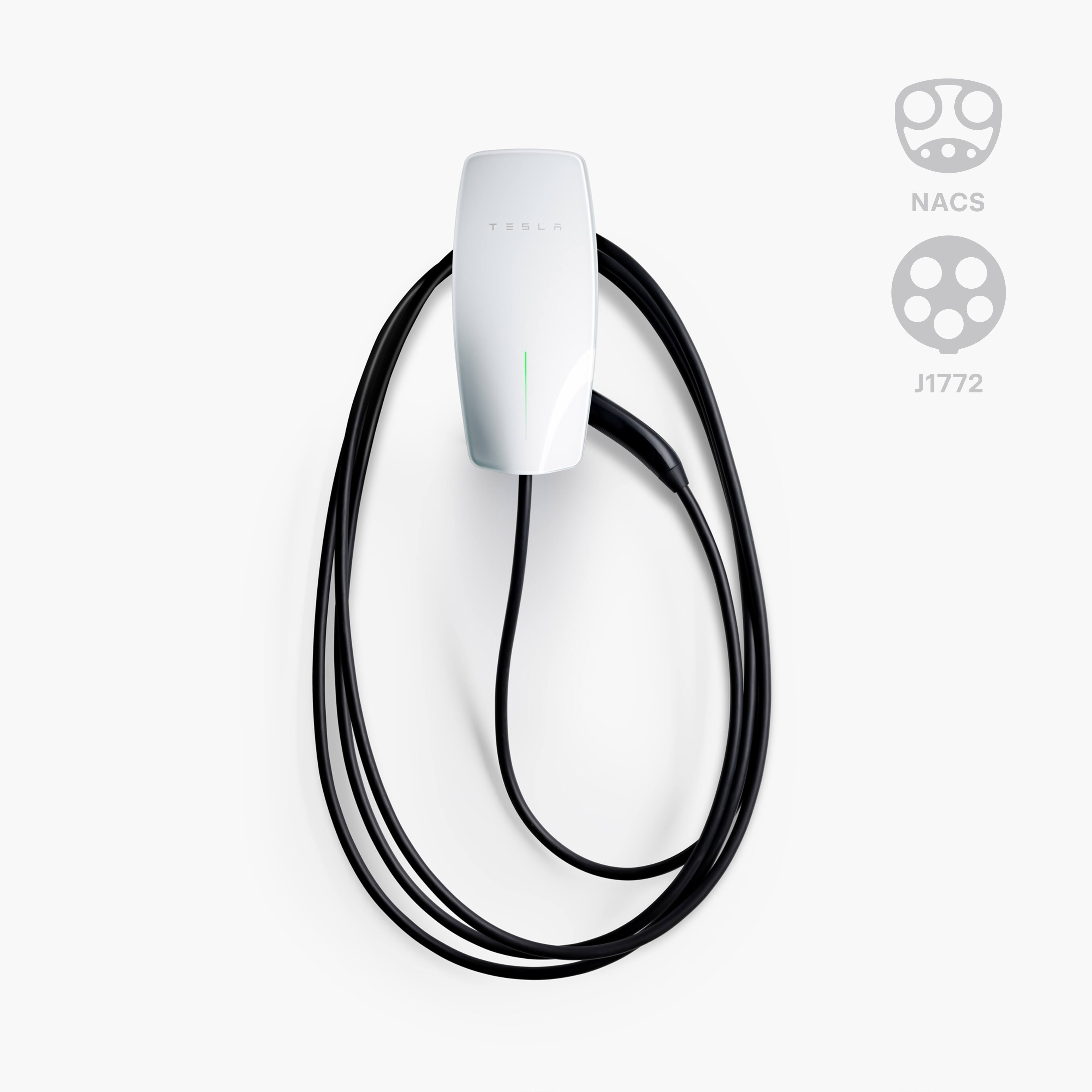 The text on the image reads "Tesla NACS J1772." This suggests that the image is related to an electric vehicle charging station, specifically designed for Tesla vehicles. The charging station is equipped with a white charger and a black cord, which is connected to the vehicle. The presence of the Tesla logo and the NACS J1772 text indicates that this is a standardized charging station for electric vehicles.