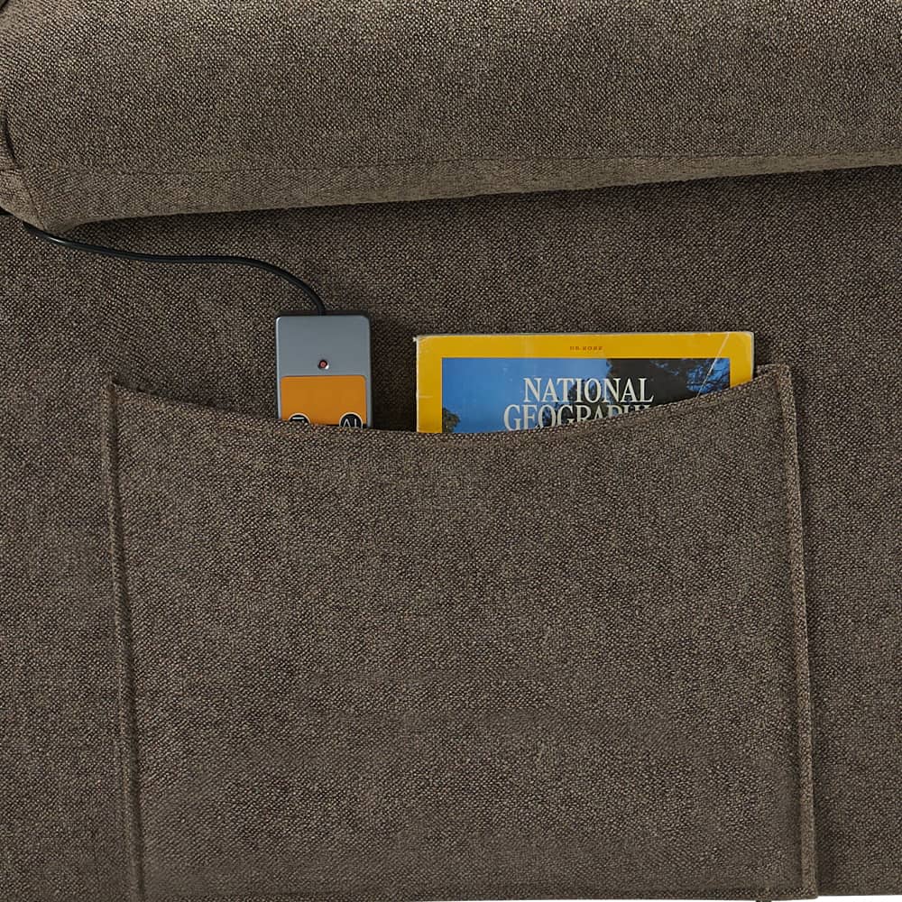 National Geographic magazine is sitting in a pocket on a couch.