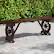 Alt View 1. Costway - Patio Rustic Wood Bench with Wagon Wheel Base Slatted Seat Design 710 LBS Max Load - Natural.