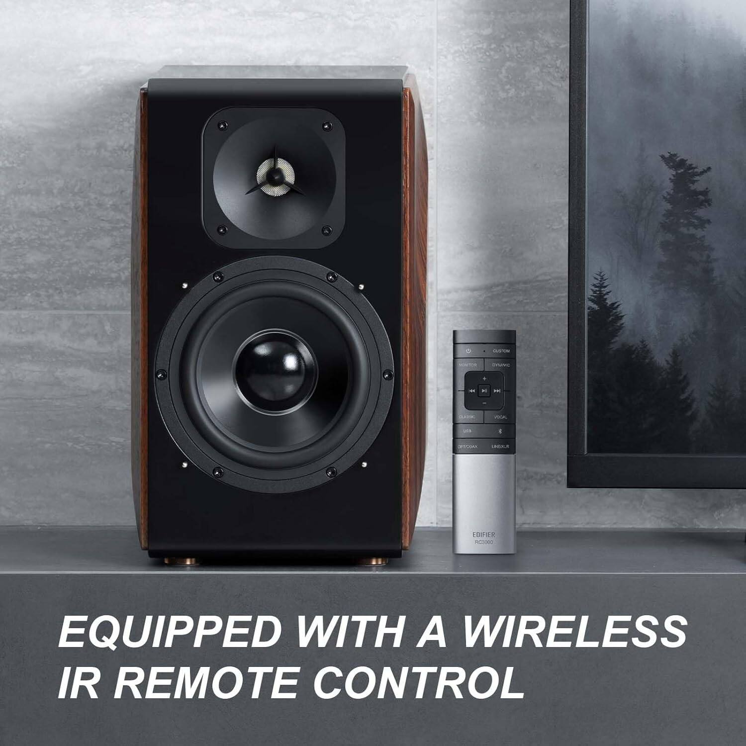 The image features a large speaker, likely a subwoofer, with a remote control sitting on top of it. The speaker is equipped with a wireless IR remote control, which allows for convenient and wireless control of the device.