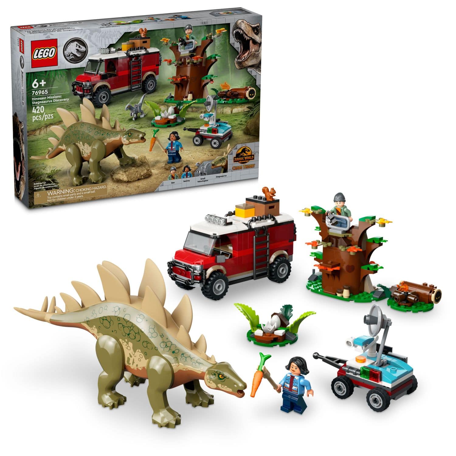The image features a Lego set with a dinosaur theme, including a T-Rex and a truck. The set contains 420 pieces and is designed for children aged 6 and above. The box also includes a warning about choking hazards. The set is displayed on a table, showcasing the various dinosaur and vehicle figures.