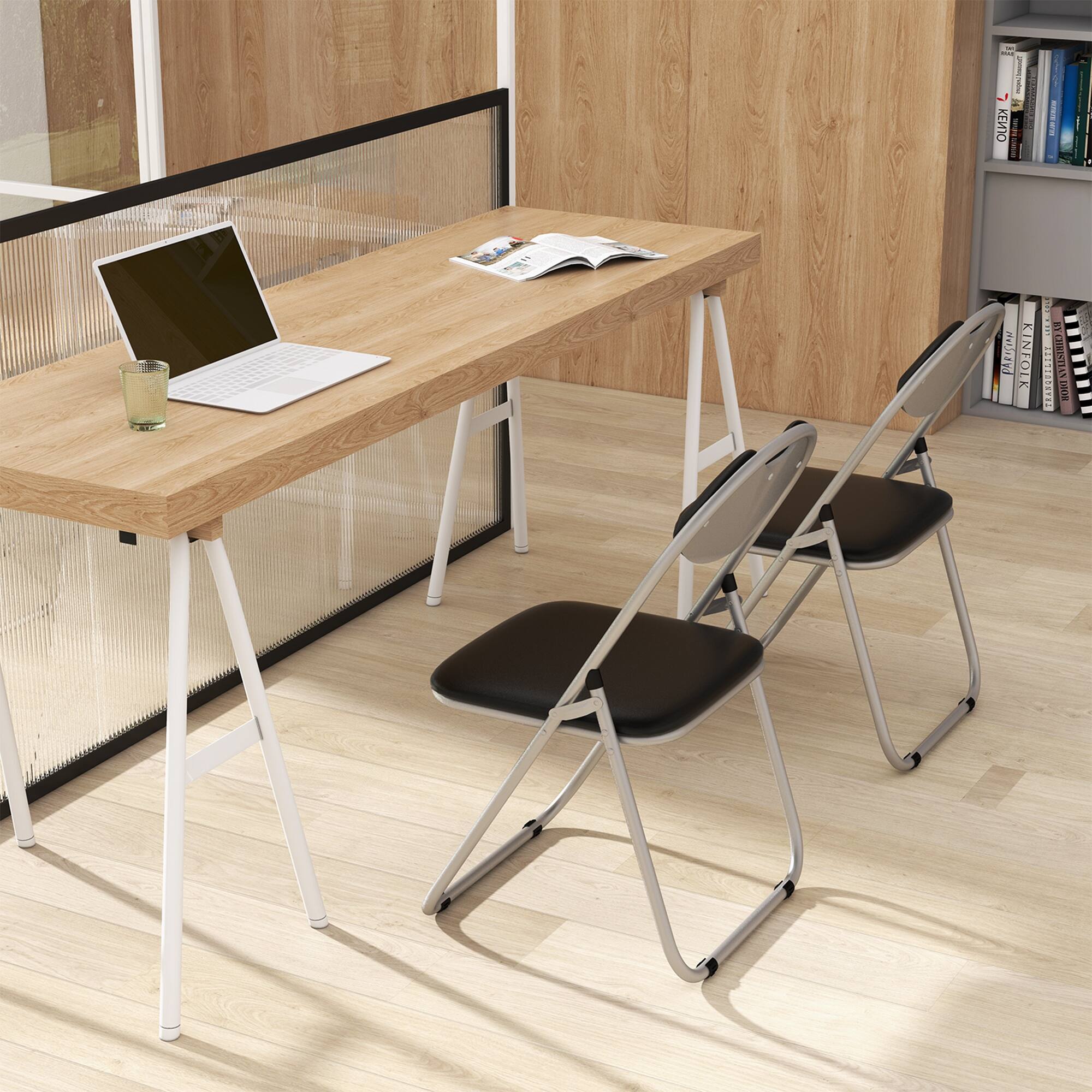 The image features a wooden desk with a laptop on it. The desk is accompanied by two chairs, one on each side. There is a book and a cup on the desk, and a cell phone is also present. The scene appears to be set in a room with a bookshelf nearby.