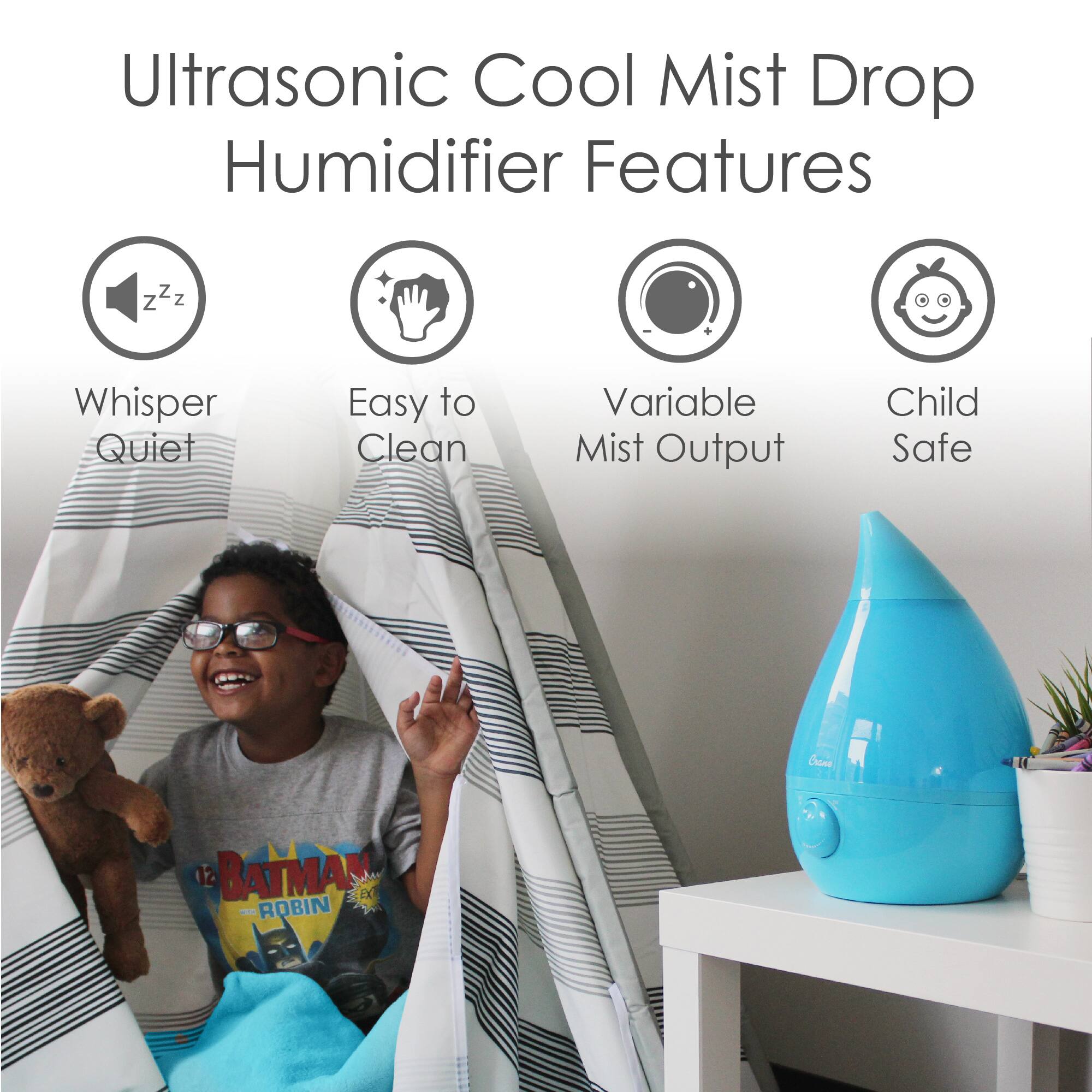 The image features a young boy sitting under a humidifier, which is designed to provide cool mist. The humidifier is placed on a table, and the boy is positioned underneath it, possibly enjoying the cool mist or playing with the device. The humidifier is described as having various features, such as a whisper quiet operation, easy-to-clean design, and a variable mist output. Additionally, the humidifier is child-safe, making it a suitable choice for families with young children.