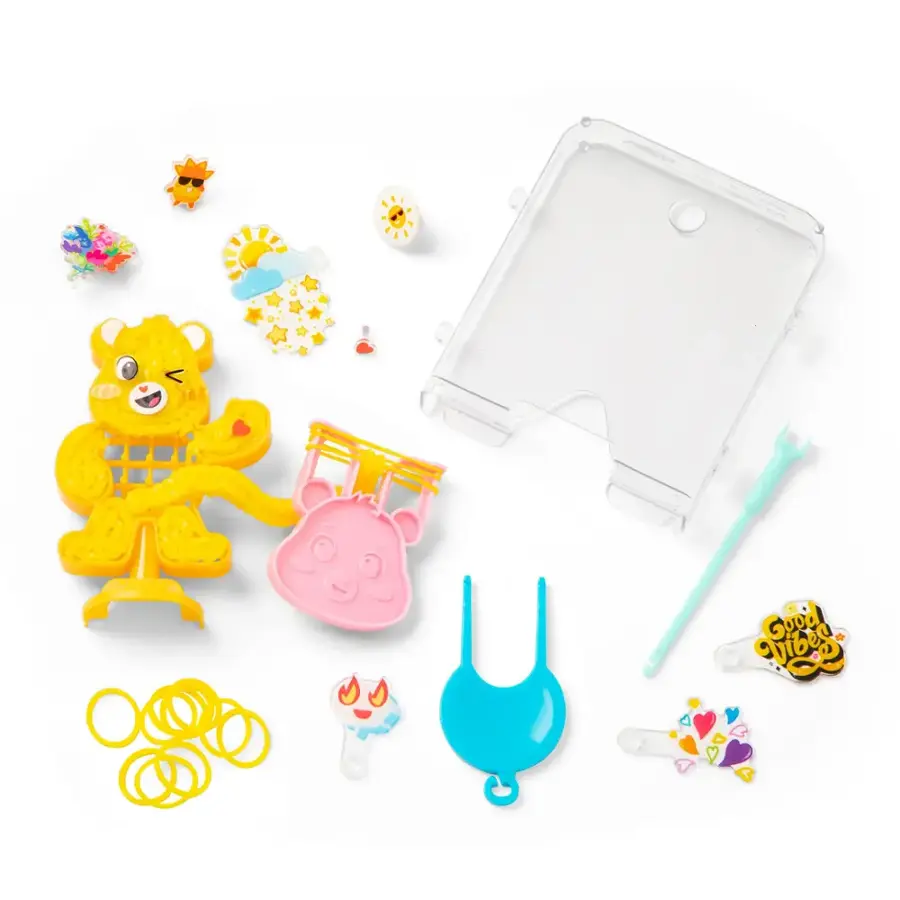 The image features a collection of toys, including a teddy bear, a toothbrush, and various other items. The toys are arranged on a table, and there is a box of toys in the background. The teddy bear is positioned near the center of the table, while the toothbrush is located towards the right side. The other items in the collection are spread out across the table, creating a diverse and colorful display.