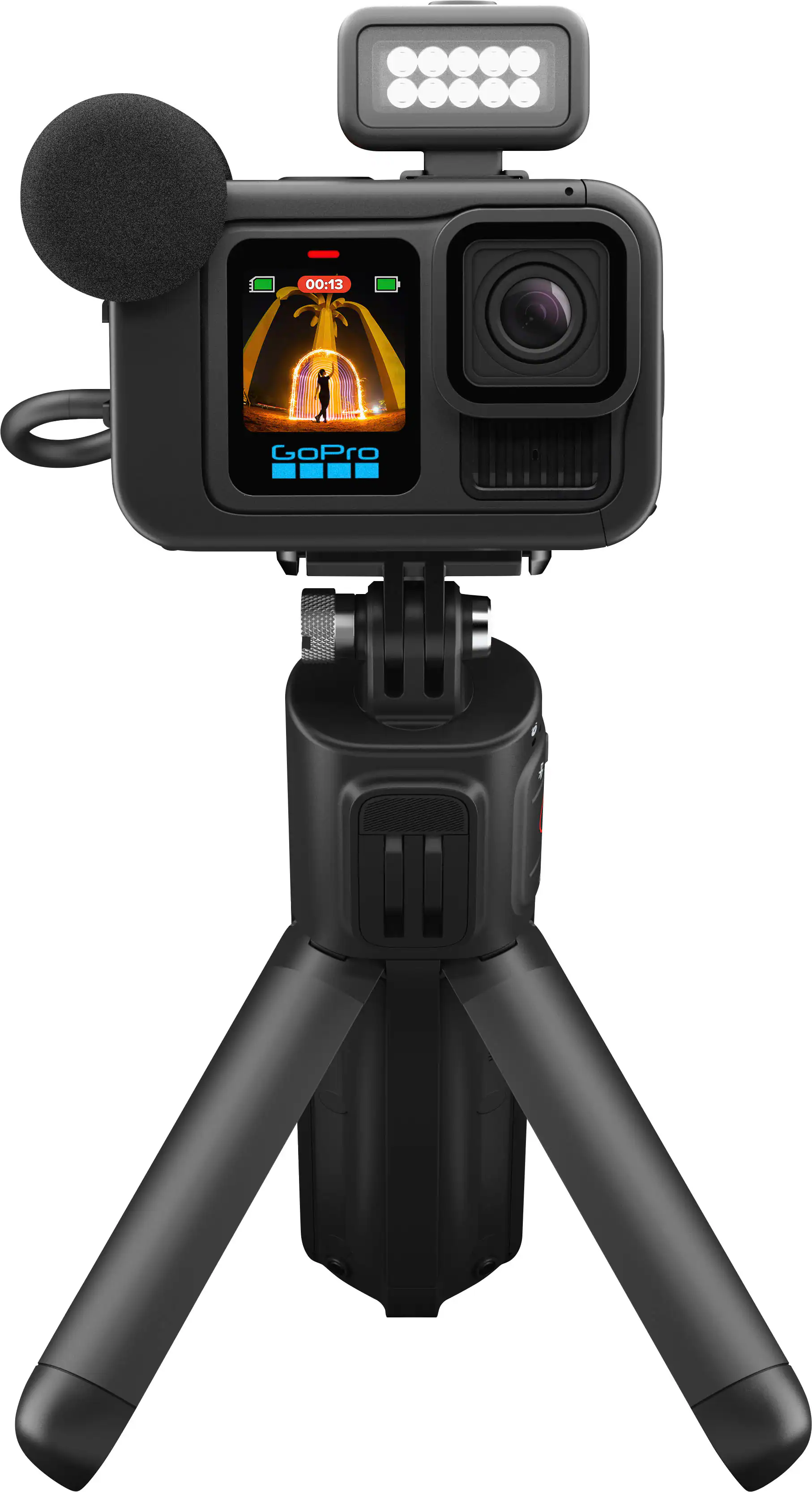 The image shows a black tripod with a camera on top of it. The camera is a GoPro, which is a compact and portable camera designed for outdoor activities and extreme sports. The tripod is set up to capture a video of a fireworks display, as indicated by the fireworks visible in the image. The camera is positioned to capture the fireworks in the background, providing a unique perspective of the event.