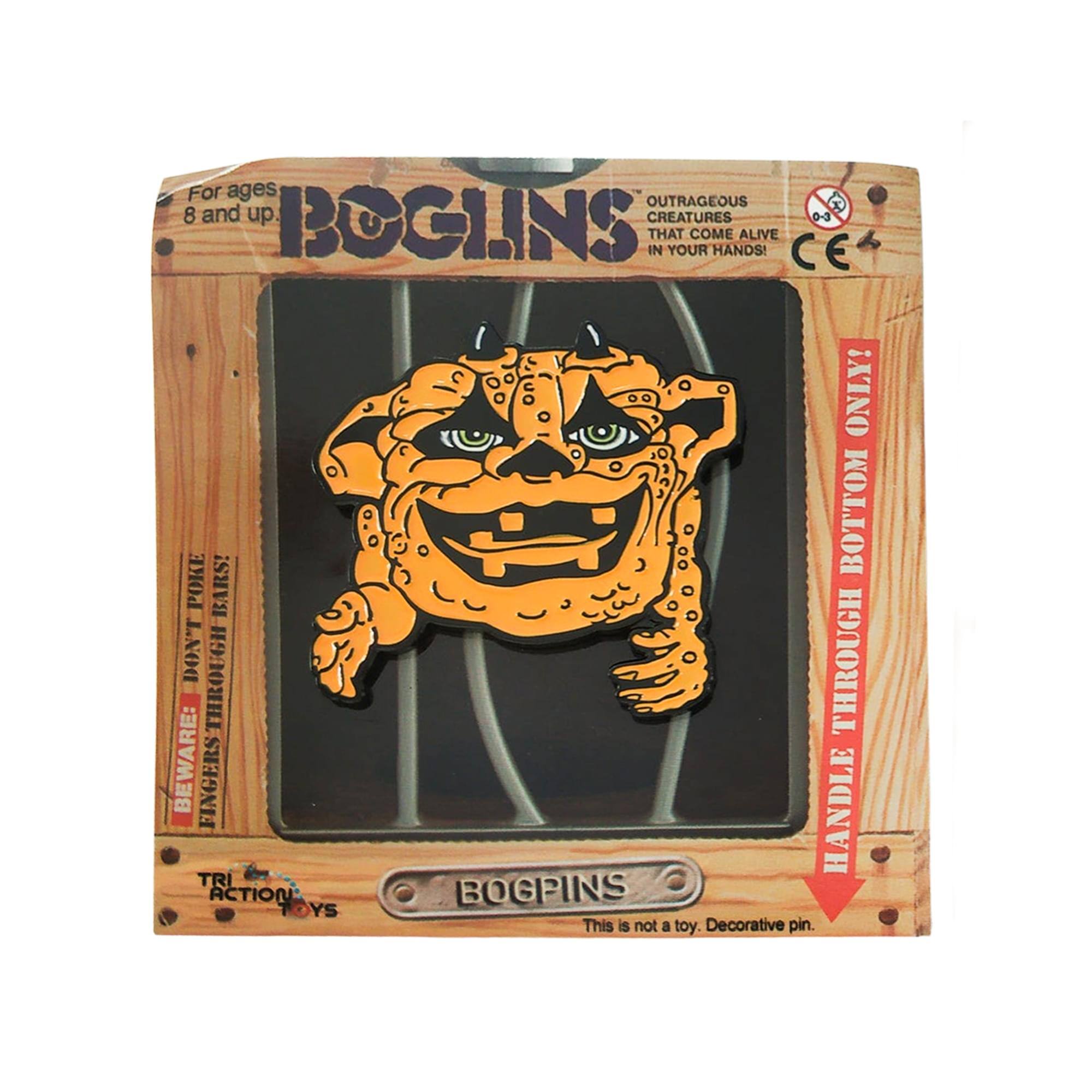 For ages 8 and up.  
BOGLINS  
OUTRAGEOUS CREATURES THAT COME ALIVE IN YOUR HANDS!  
CE 0-3  
BEWARE: FINGERS THROUGH BOTTOM BARS!  
HANDLE THROUGH BOTTOM BARS!  
This is not a toy. Decorative pin.  
TRI ACTION TOYS