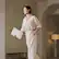 The image does not contain any text to group or correct. It shows a person standing in a room, holding a laptop.