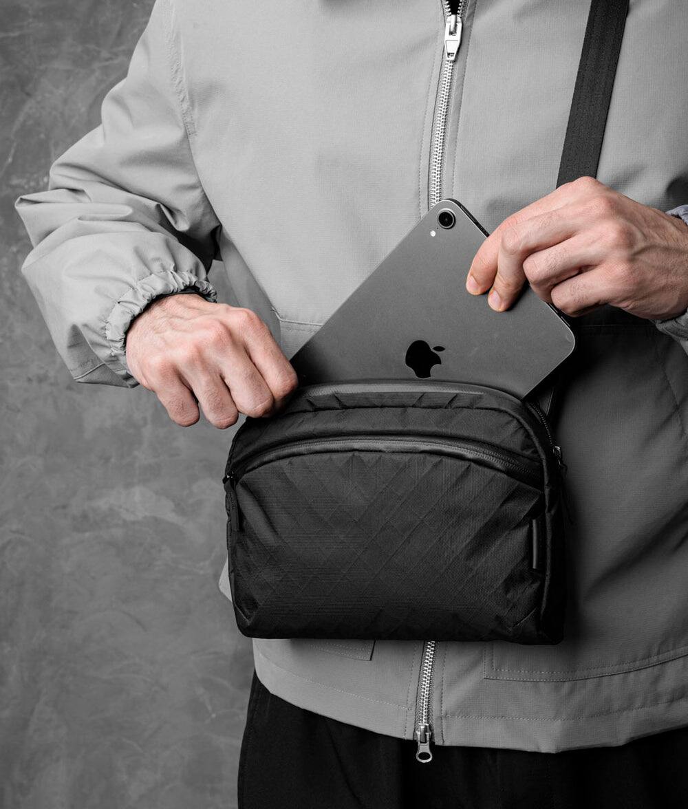Left. ALPAKA - Flight Sling 2L Travel Sling Bag, Lightweight Packable Crossbody Pouch, Fits iPad Mini/Switch, Passport Pocket - Black Ultradyne 100D.
