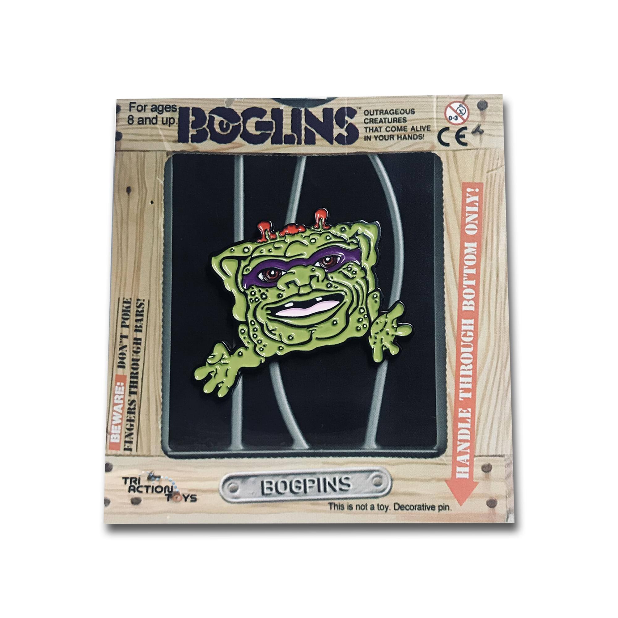 For ages 8 and up.  
BOGLINS  
OUTRAGEOUS CREATURES THAT COME ALIVE IN YOUR HANDS!  
CE 0-3  
BOTTOM ONLY!  
HANDLE THROUGH BOTTOM!  
BEWARE: FINGERS THROUGH!  
This is not a toy. Decorative pin.  
TRI ACTION TOYS