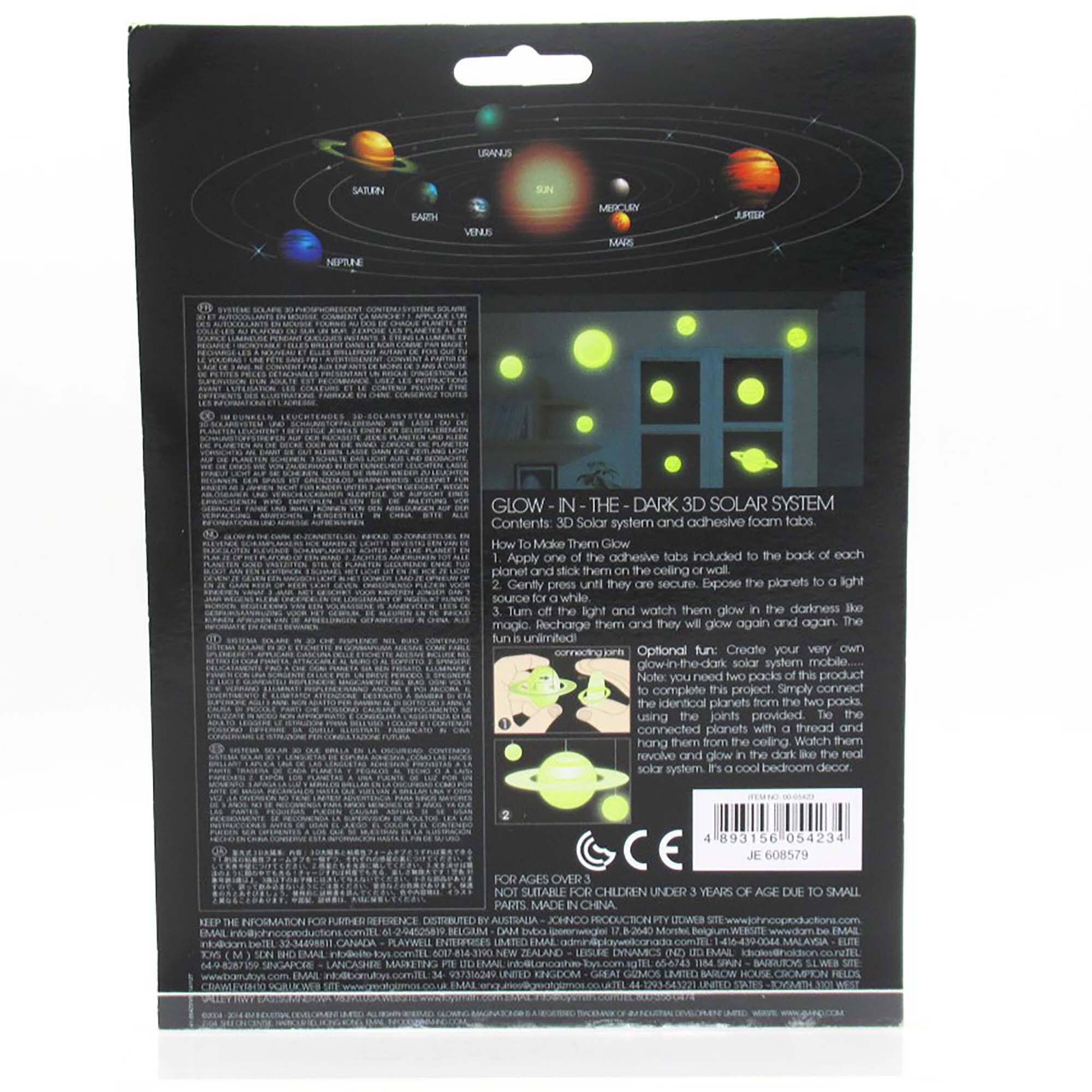 The image features a black box containing a Glow in the Dark Solar System, which includes a 3D solar system and adhesive foam tabs. The box also has a description of how to use the product, which involves applying the adhesive tabs to the back of each planet and sticking them to the ceiling or wall. The planets will glow in the dark when exposed to light, and they can be recharged for continued glowing. The product is intended for ages over 12 years old due to small parts, and it is made in China. The box also has a barcode and a CE mark for reference.