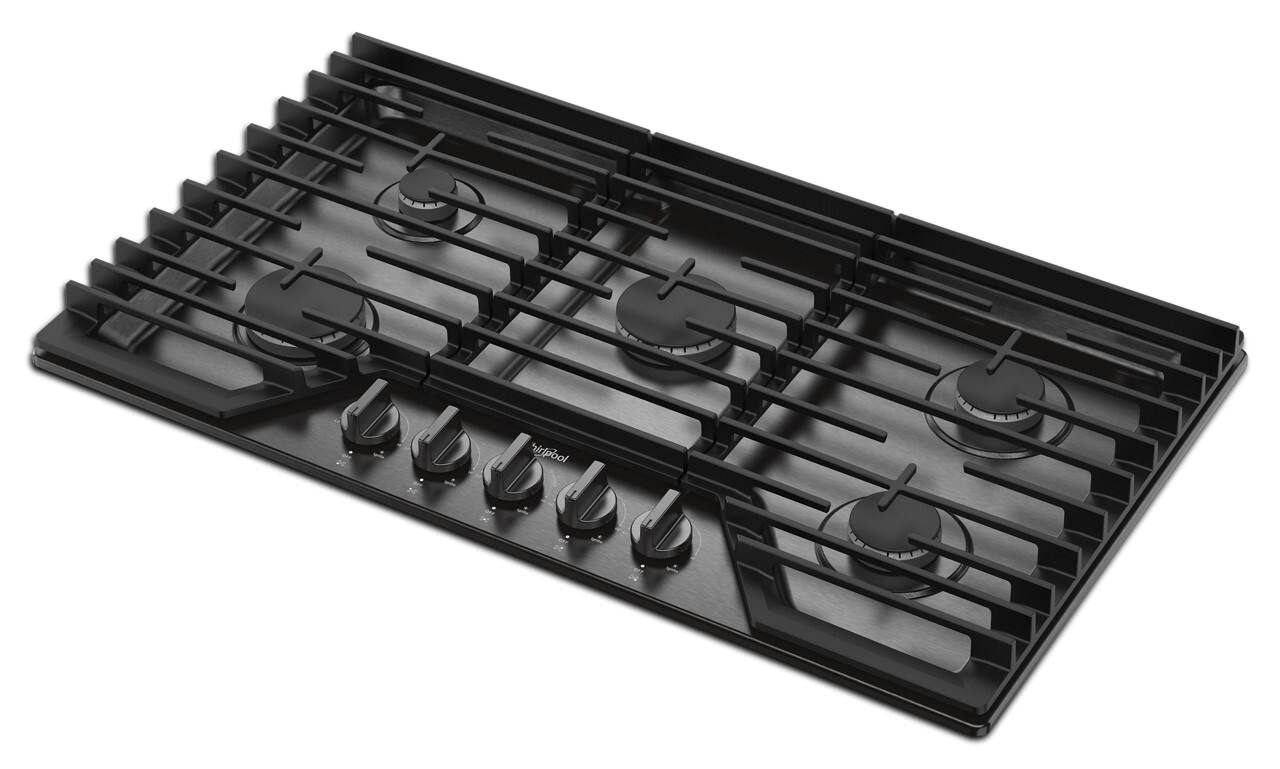 The image features a black stove top with six burners. The burners are arranged in a square pattern, with three burners on each side. The stove top is placed on a white background, which highlights the burners and their arrangement. The stove top appears to be a modern and sleek design, suitable for various cooking needs.