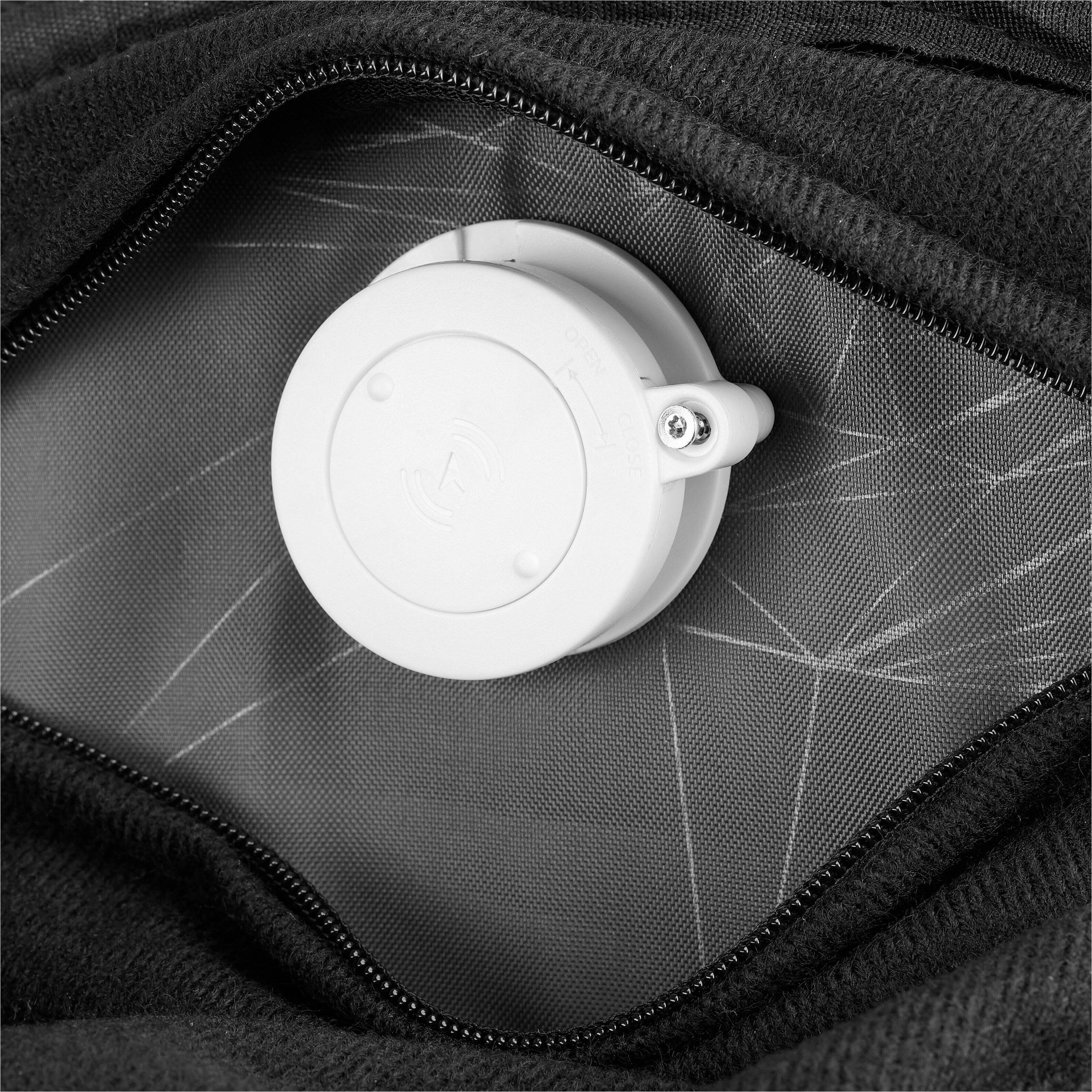 The image shows a white object with a black background. The object has a button on it, which can be used to open or close it. The button is located on the top of the object, making it easily accessible for the user. The object is placed in a pocket, which suggests that it might be used for carrying or storing items.