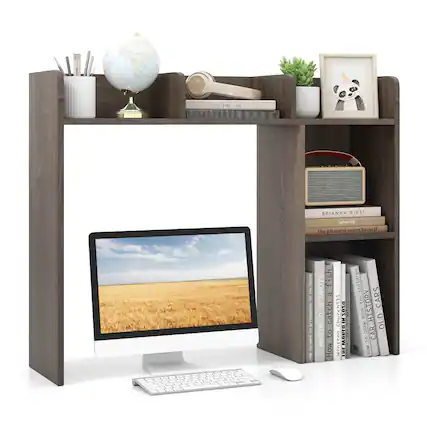 The image features a computer desk with a desktop computer, a keyboard, and a mouse. The desk is also adorned with various items, including a bookshelf filled with books, a potted plant, a clock, a vase, and a cup. The books on the shelf are arranged in a way that they are not stacked on top of each other. The desk is situated in a room with a window, providing a pleasant view for the person working at the desk.