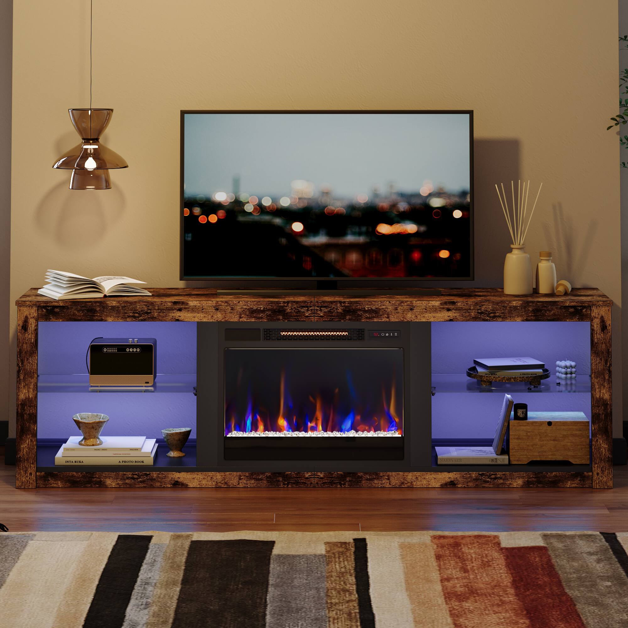 The image features a living room with a flat screen TV mounted on the wall above a fireplace. The fireplace has a fire going, creating a warm and cozy atmosphere. The room also has a bookshelf with several books, a vase, and a potted plant. The TV is turned on, and the room appears to be well-organized and inviting.