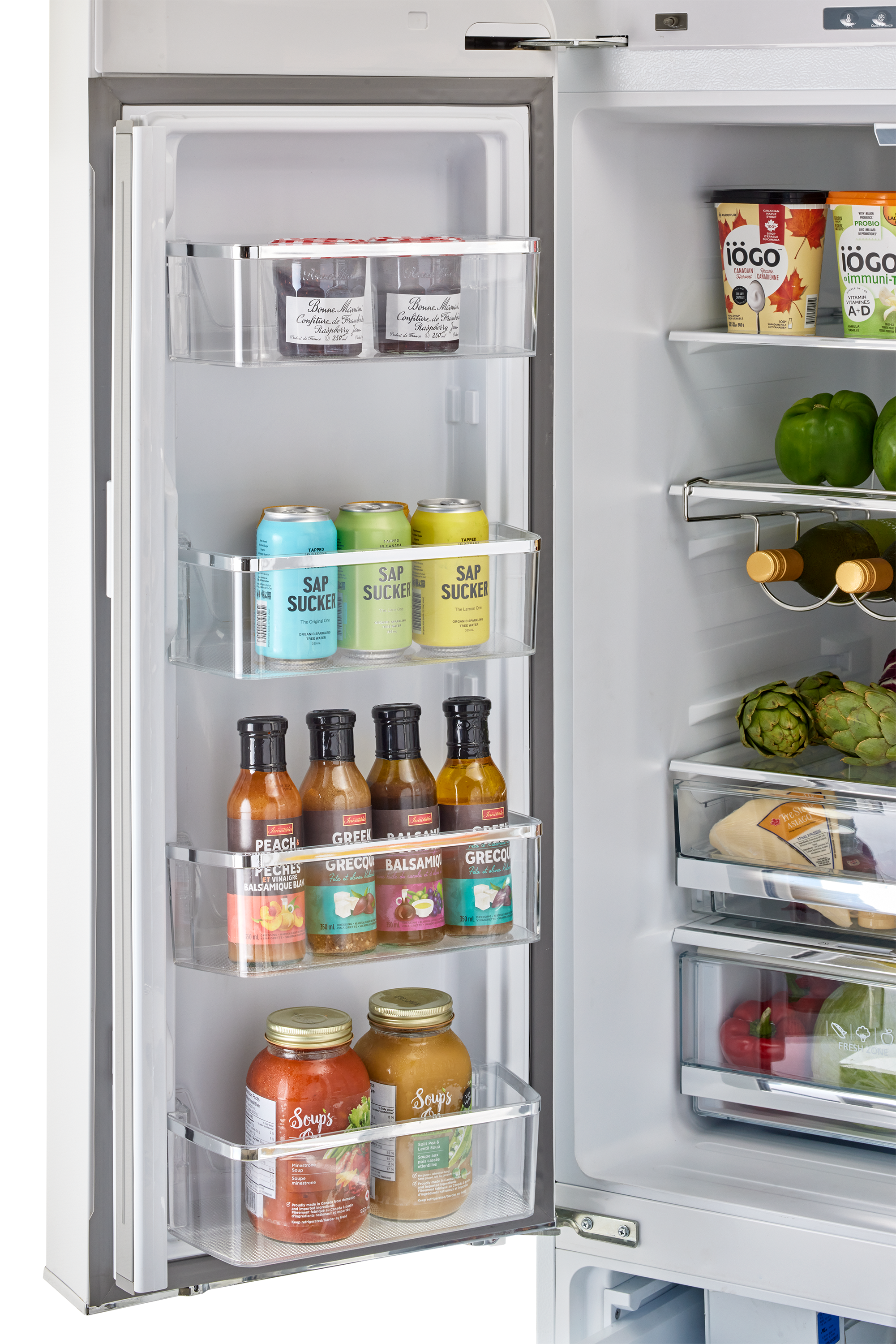 The refrigerator is stocked with a variety of food items, including several bottles of sauces and condiments. There are also fruits and vegetables, such as apples and broccoli, stored in the refrigerator. The refrigerator is organized with shelves and compartments to keep the items neatly arranged and easily accessible.