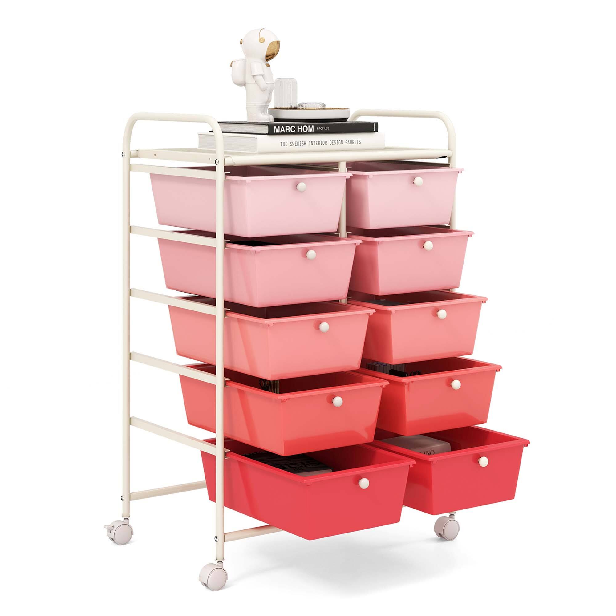The image features a white and pink cart with a variety of storage containers. The cart is filled with red and pink plastic bins, which are stacked neatly on the cart. The cart is placed in front of a book, possibly a cookbook, and a teddy bear. The storage containers are organized in a way that maximizes space and makes it easy to access the contents. The cart is a versatile and practical storage solution for various items, such as kitchen utensils, office supplies, or personal belongings.