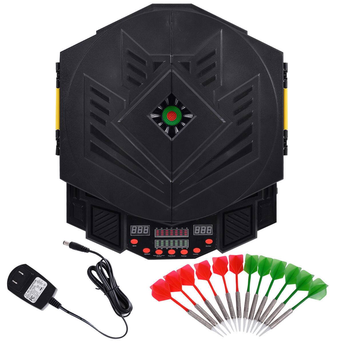The image shows a black object with a green light in the center. There are also several red and green darts arranged around the object. The object appears to be a game controller, and the darts are likely used for a game. The darts are arranged in a circular pattern, with some of them pointing upwards. The scene also includes a power cord and a remote control, suggesting that the game controller is connected to a power source and can be controlled by the remote.