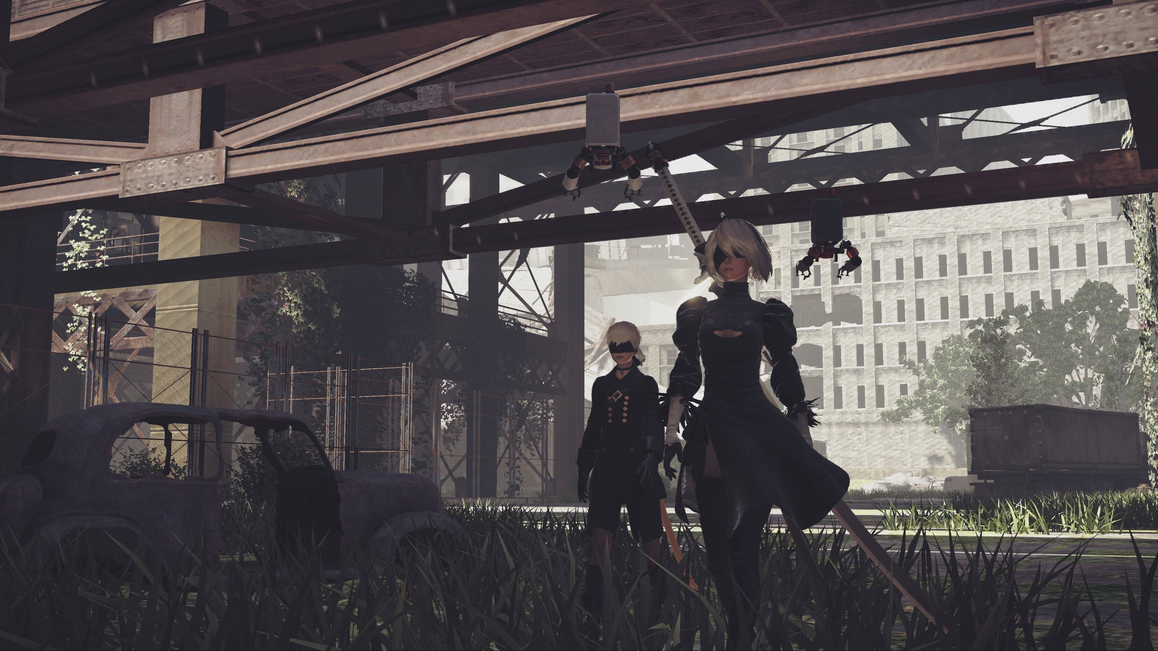 Two people are standing in a grassy area. One person is holding a sword, while the other person is holding a bow. They are both wearing black clothing.