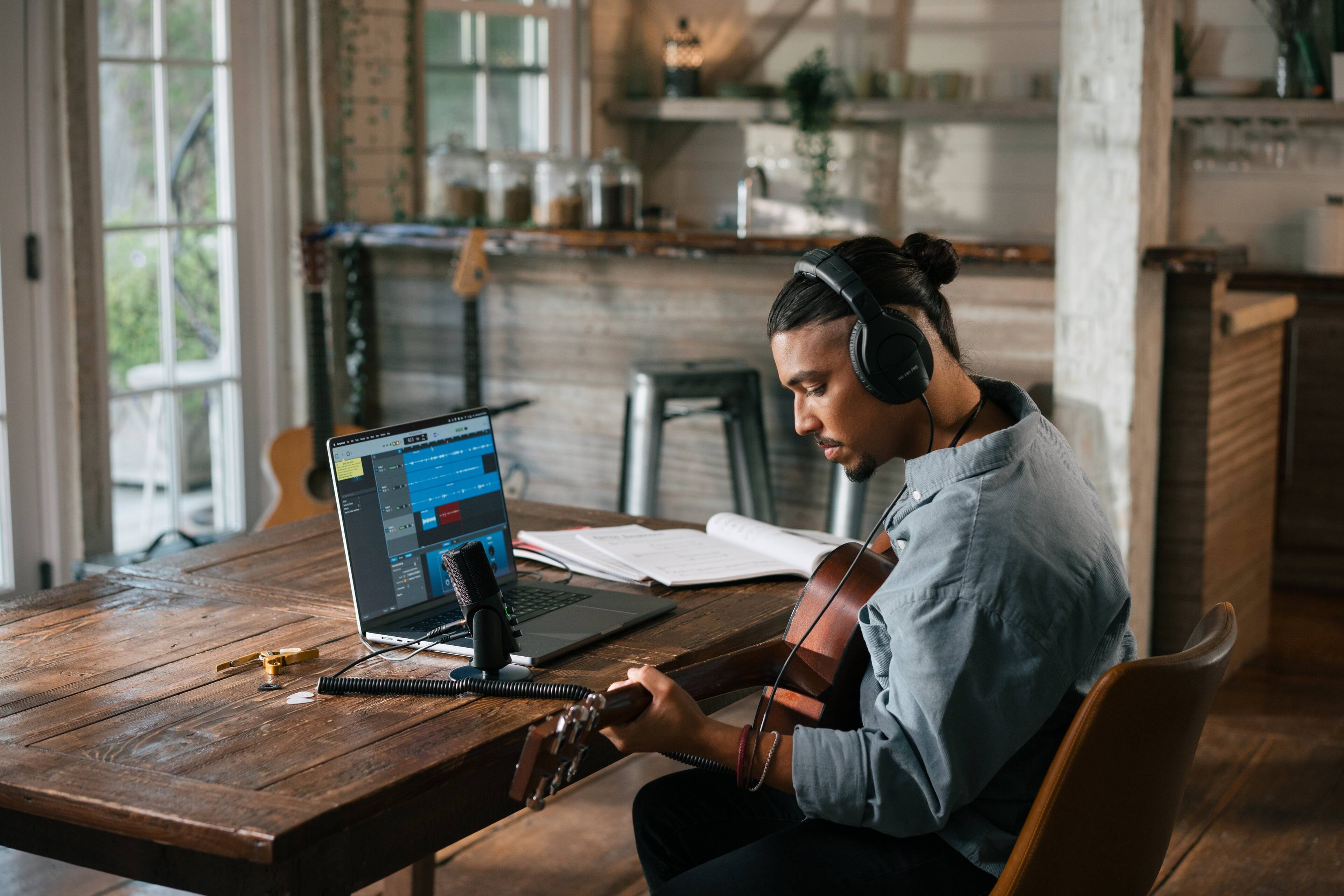 I'm sorry, but I cannot group or correct the text as there is no text provided in the image description. The image description only contains a description of the man playing guitar in front of a laptop.