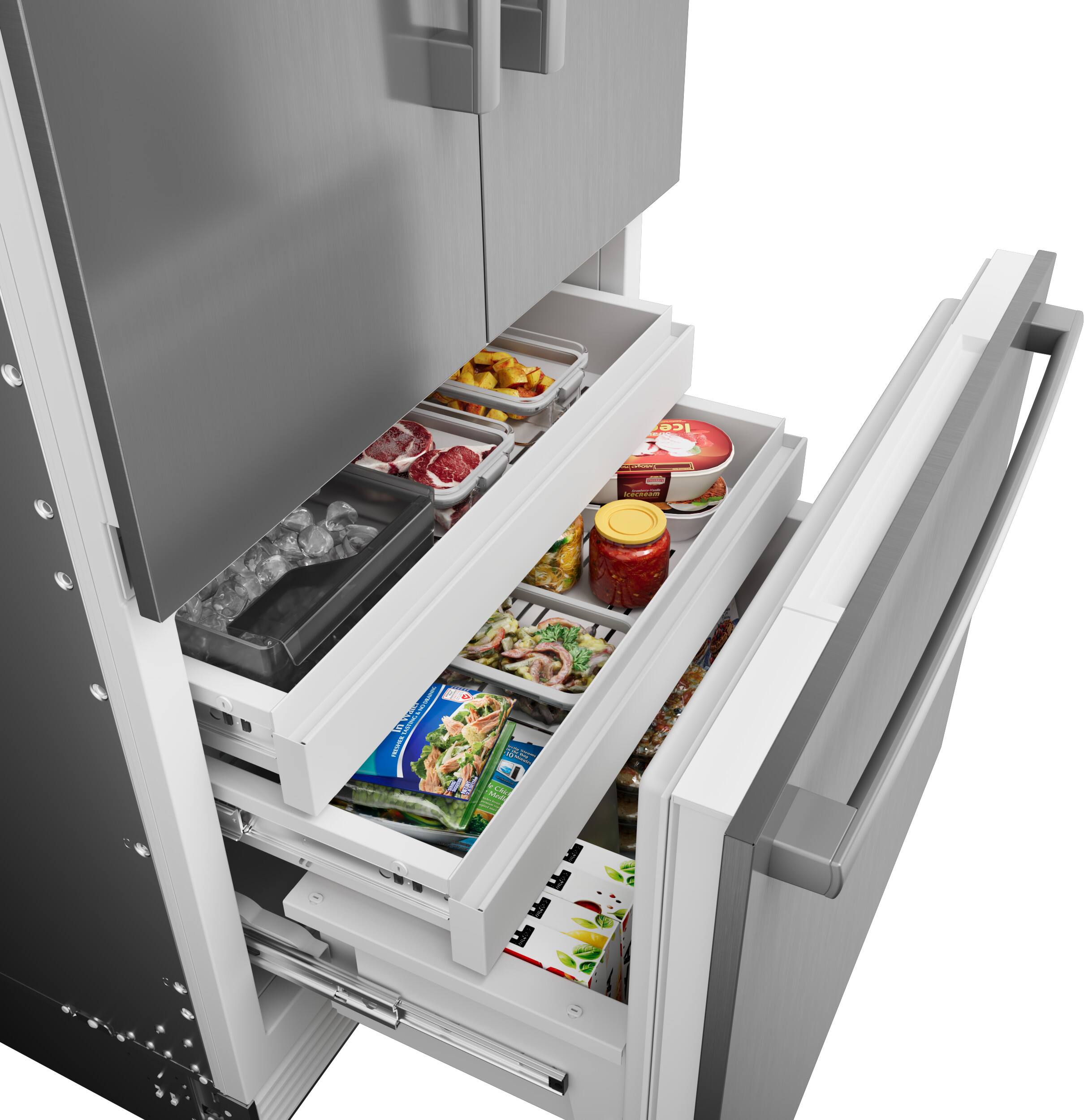 The text on the image reads "M Ice I AIra I a ER I - B5 -." However, it is not clear what this text represents or how it relates to the image. The image shows a refrigerator with its door open, revealing a drawer filled with various food items such as vegetables, meat, and condiments.