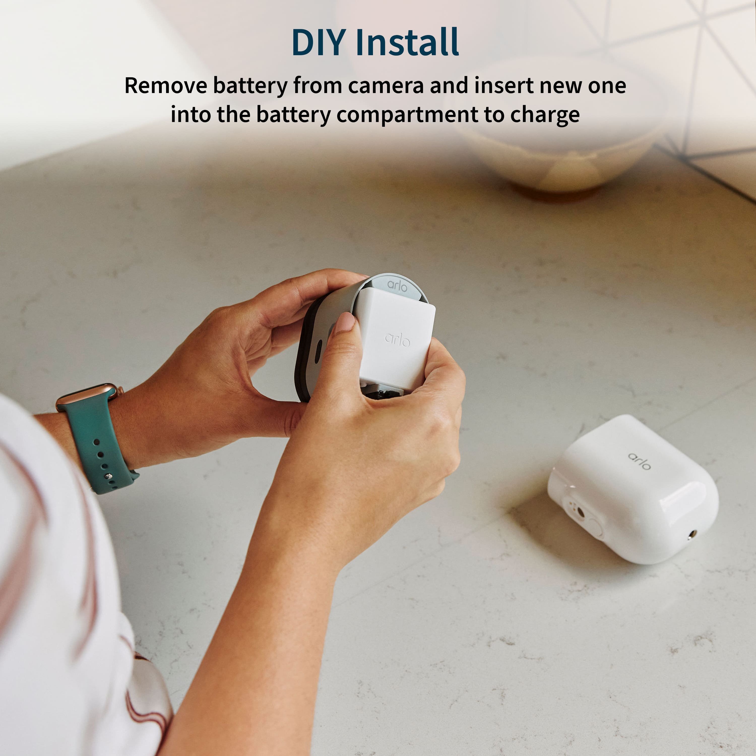 DIY Install: Remove battery from camera and insert new one into the battery compartment to charge Arlo.