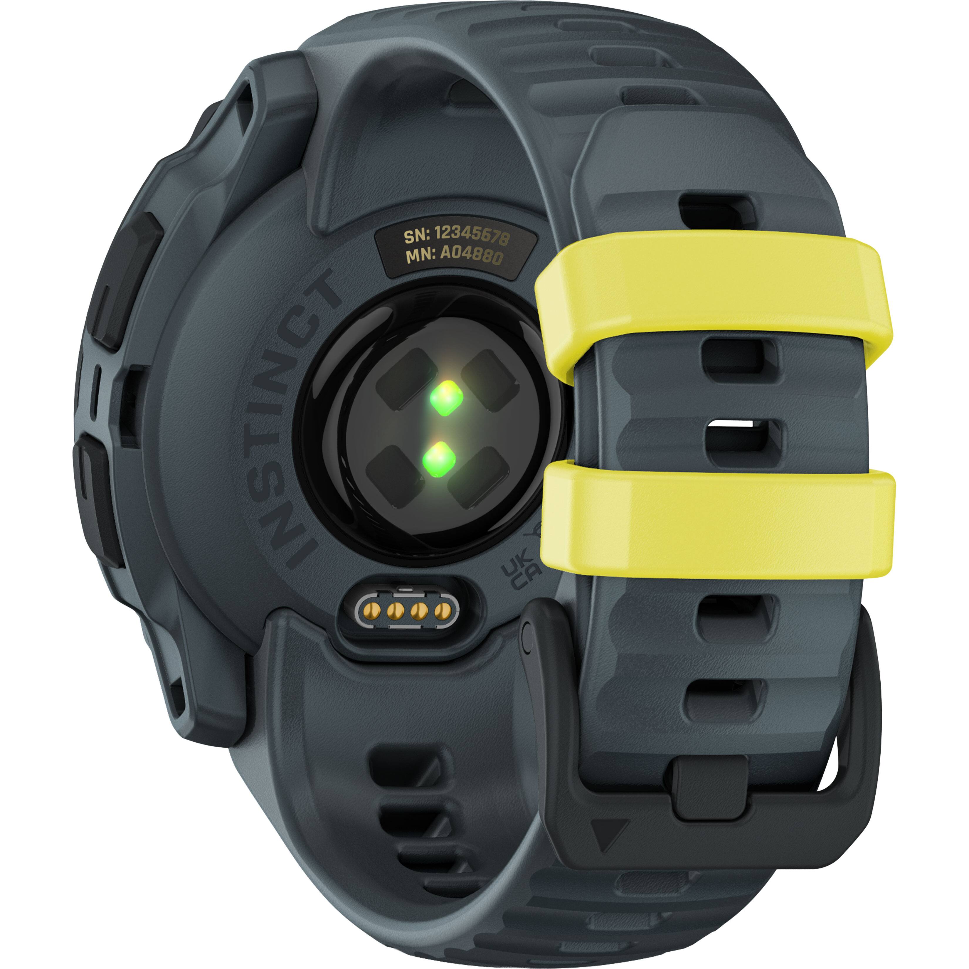 The watch is an Instinct watch with a yellow band. The watch has a green light on the face and is a black and yellow color. The watch is designed for outdoor activities and features a GPS and compass.