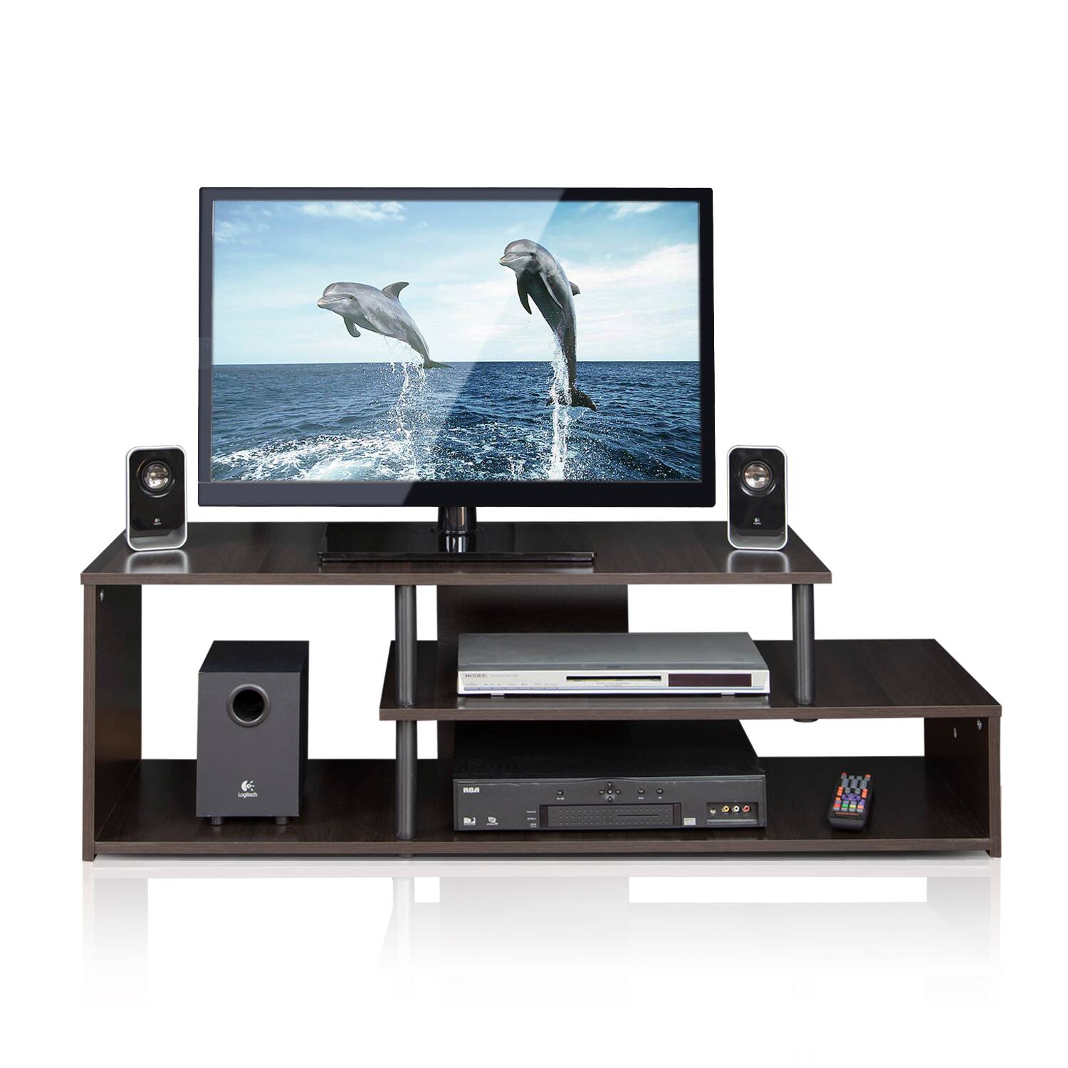 The image shows a modern entertainment setup with a flat-screen TV displaying dolphins jumping in the ocean. Below the TV, there is a black media console with shelves holding various electronic devices, including a soundbar, speakers, a DVD player, and a gaming console. The setup is sleek and organized, with a remote control placed on the lower shelf.