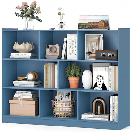 The image features a blue bookshelf filled with various items. There are several books of different sizes placed on the shelves, as well as a vase and a potted plant. Additionally, there are two clocks on the shelf, one towards the left side and the other towards the right side. A pair of scissors can also be seen on the shelf, located near the middle. The bookshelf is well-organized and showcases a diverse collection of items.
