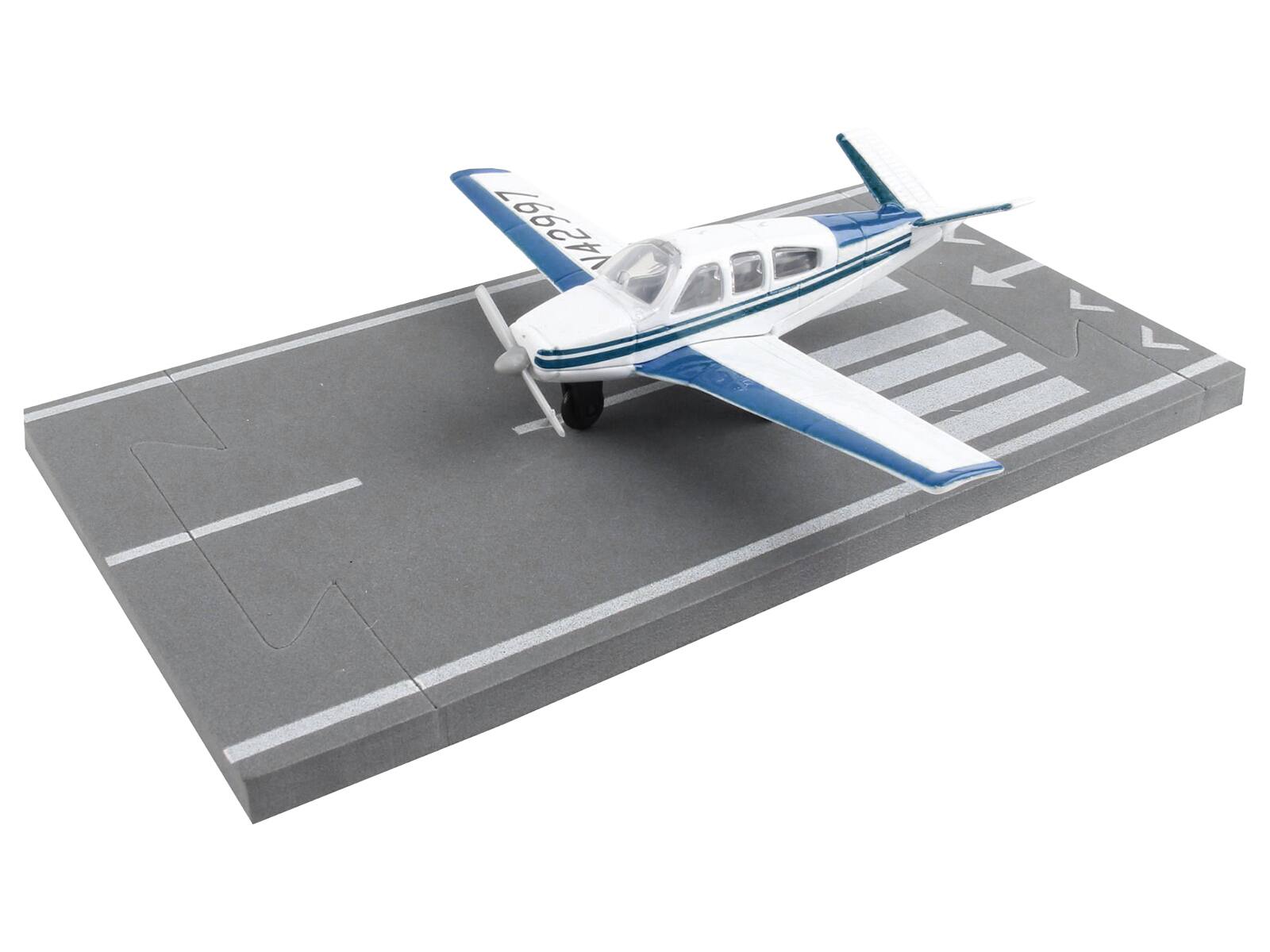 Left. Runway24 - Beechcraft Bonanza Aircraft White with Blue Stripes "N42997" with Runway Section Diecast Model Airplane by Runway24 - White with Blue.