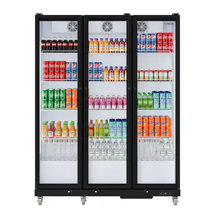 The refrigerator is filled with a variety of drinks, including sodas, juices, and water. There are several bottles of soda, such as Coca-Cola, placed in the refrigerator, along with bottles of juice and water. The refrigerator is well-stocked and offers a wide selection of beverages for different preferences.