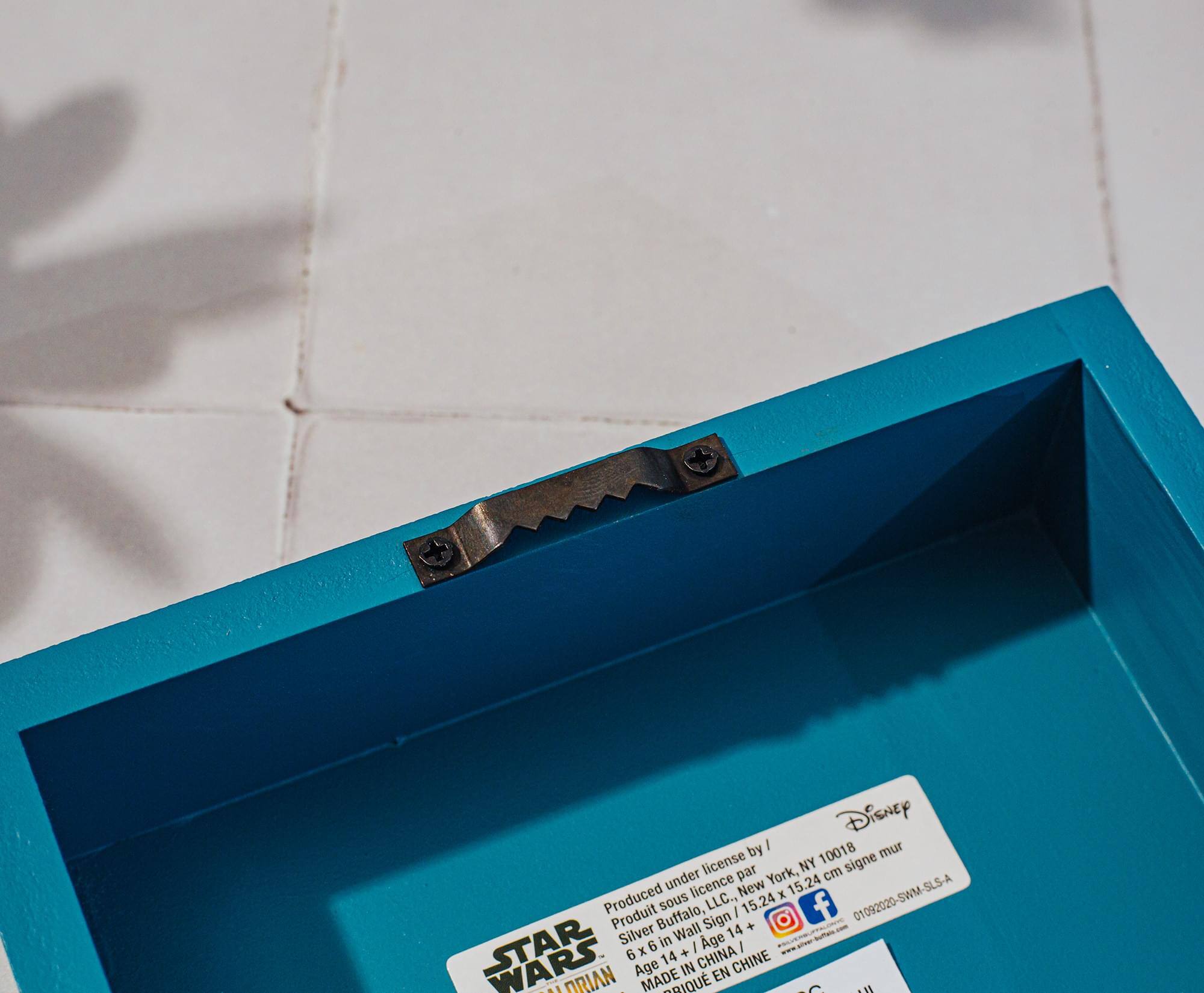 Disney by I mur license NY 10018 signe under par York, cm licence New K 15.24 Produced Produit Buffalo, sous Sign LLC., I 15.24 f 01092020-SWM-SLS-A Wall 14 + STAR Silver 6 in Age x + I i 6 14 CHINA CHINE Age IN EN A1 RIAN - t MADE RIQU  u

Corrected text:

Produced under license by Silver Buffalo Sign, LLC. New York, NY 10018  
Disney  
Produit sous licence par Silver Buffalo Sign, LLC. New York, NY 10018  
6 in x 14 in / 15.24 cm x 35.56 cm  
Age 14+ / 14 ans et +  
MADE IN CHINA / FABRIQUÉ EN CHINE  
01092020-SWM-SLS-A  
STAR WARS  
AUTHENTIC